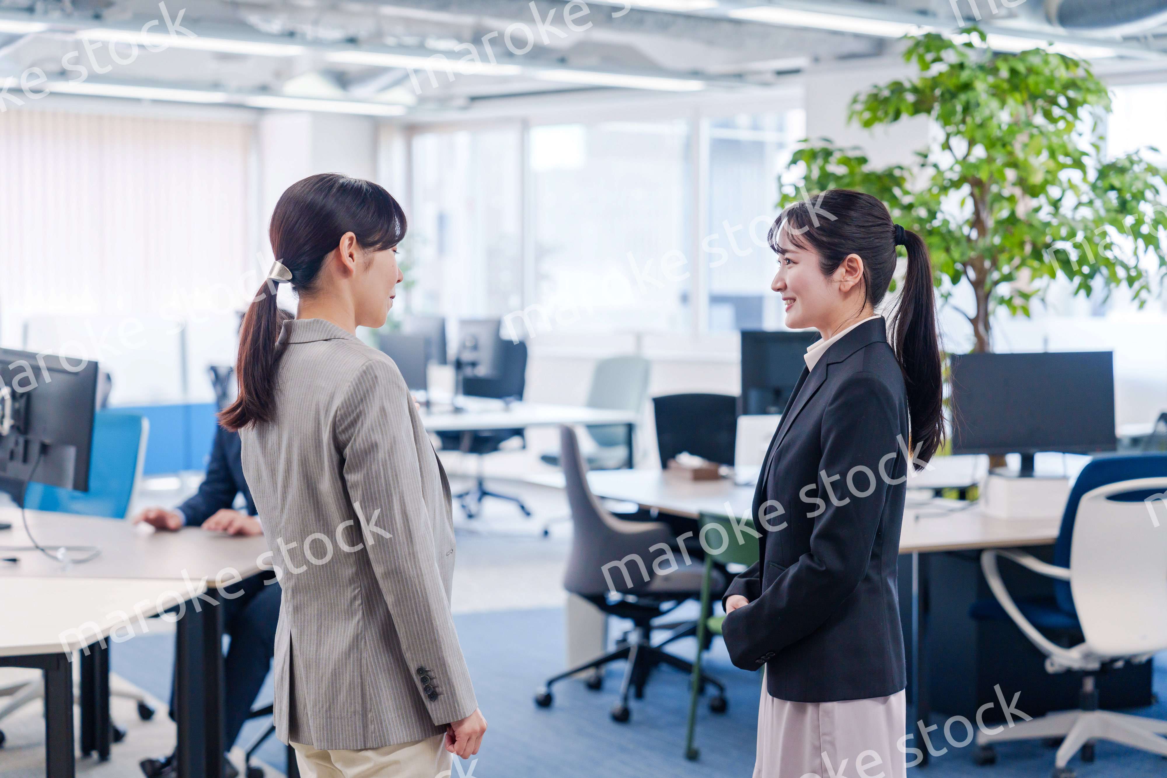 先輩社員にオフィスを案内してもらうフレッシュな女性