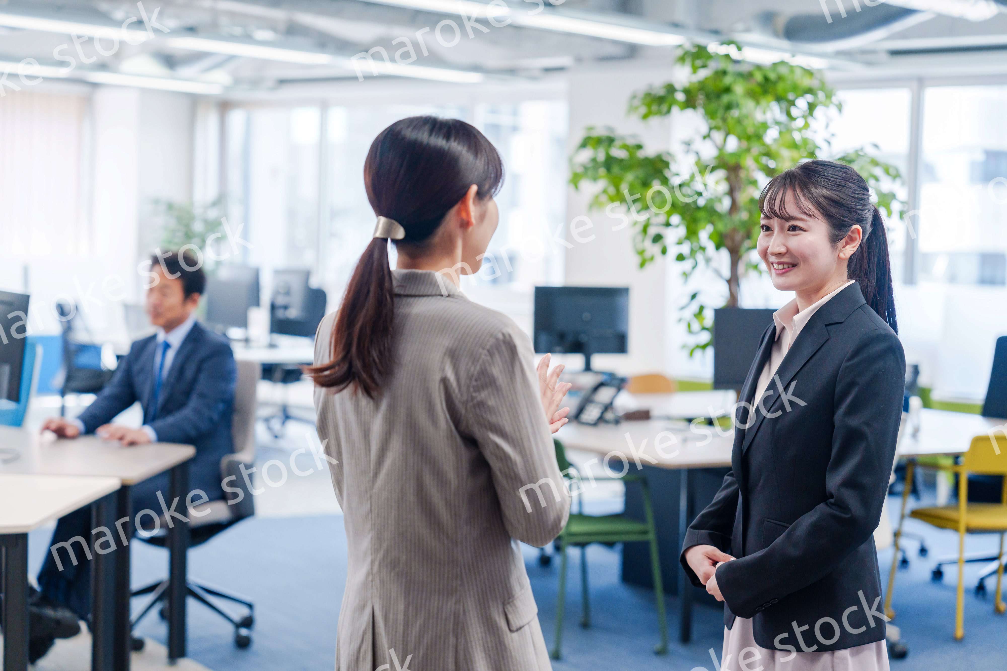 先輩社員にオフィスを案内してもらうフレッシュな女性