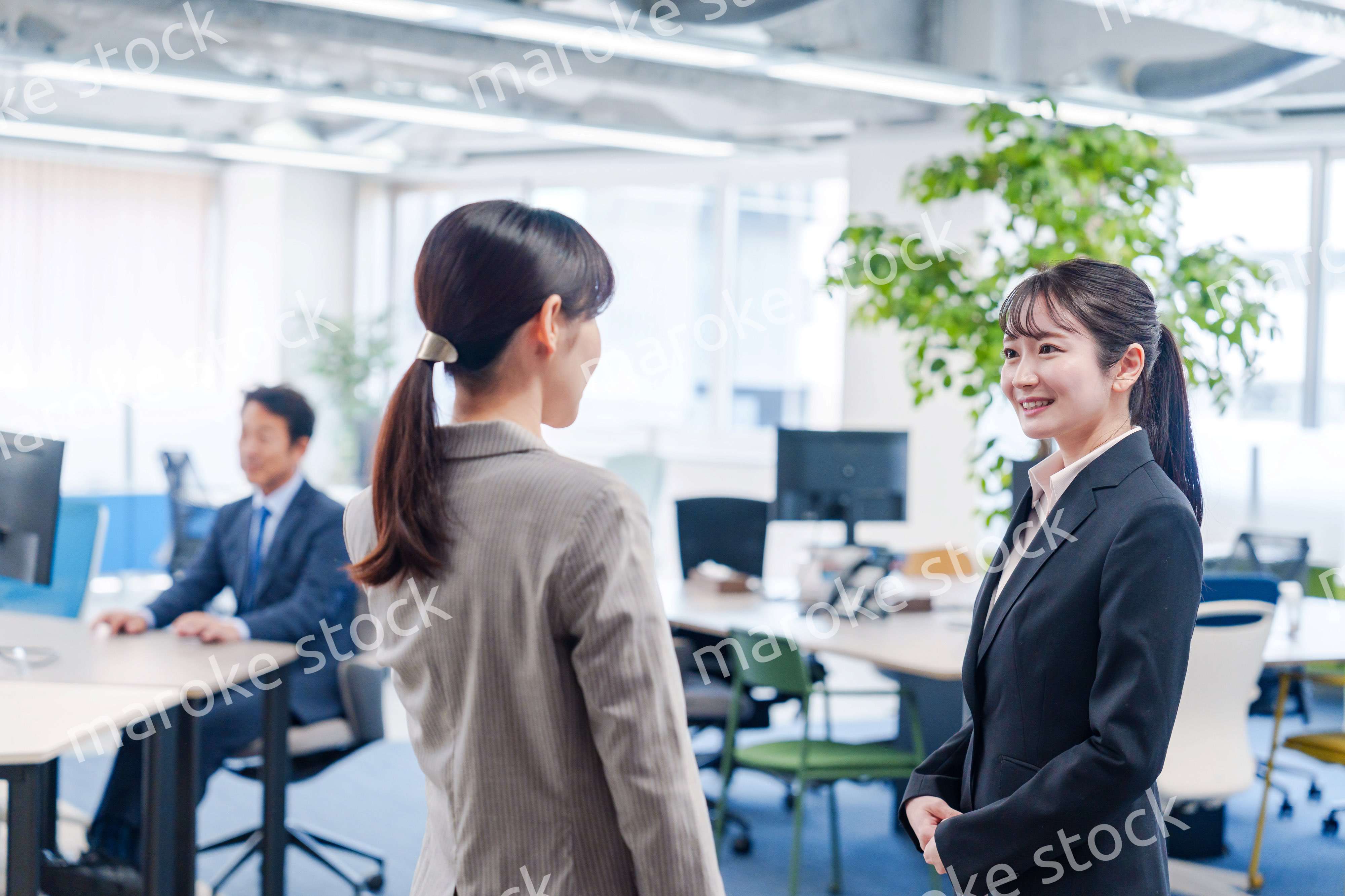 先輩社員にオフィスを案内してもらうフレッシュな女性