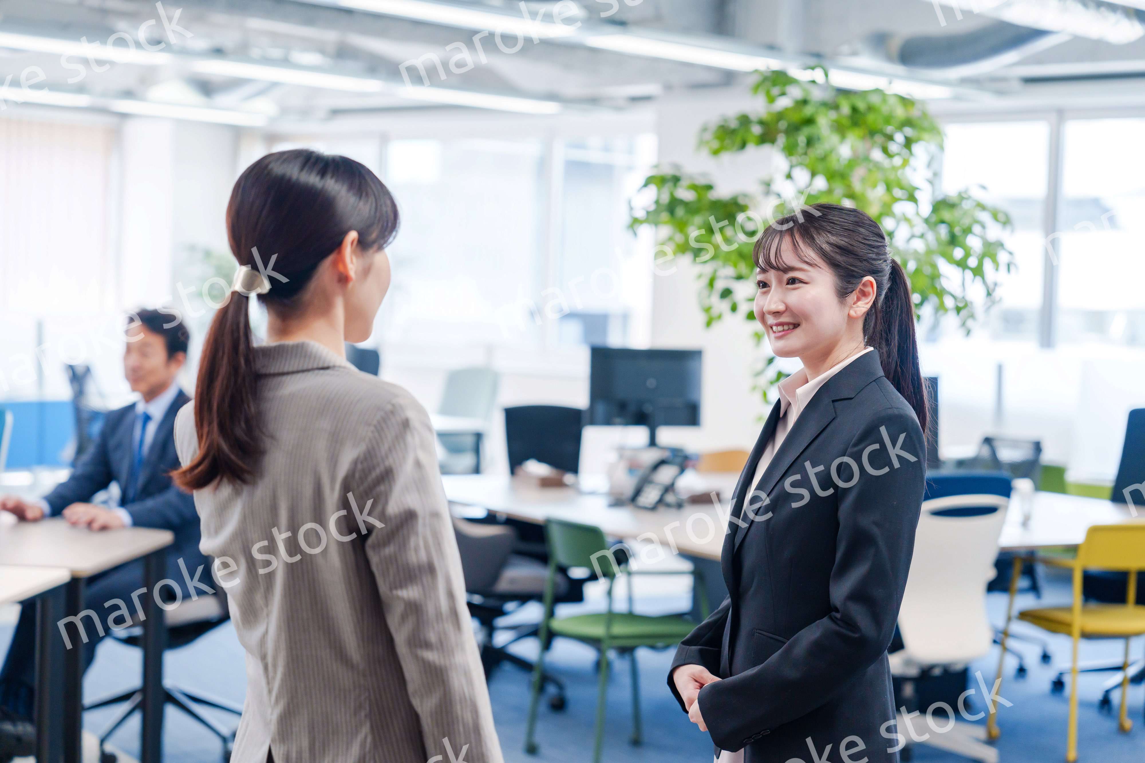 先輩社員にオフィスを案内してもらうフレッシュな女性