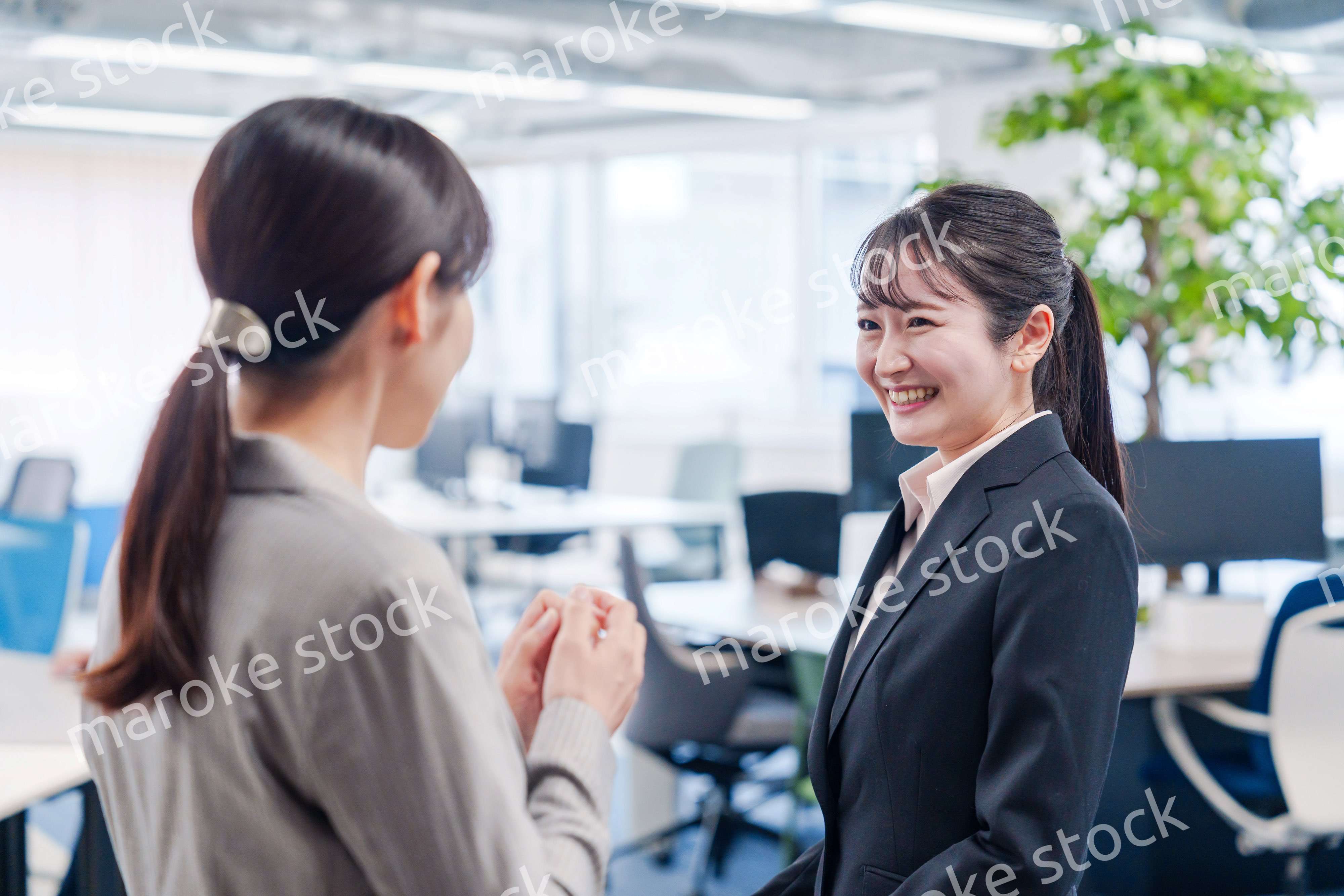 先輩社員にオフィスを案内してもらうフレッシュな女性