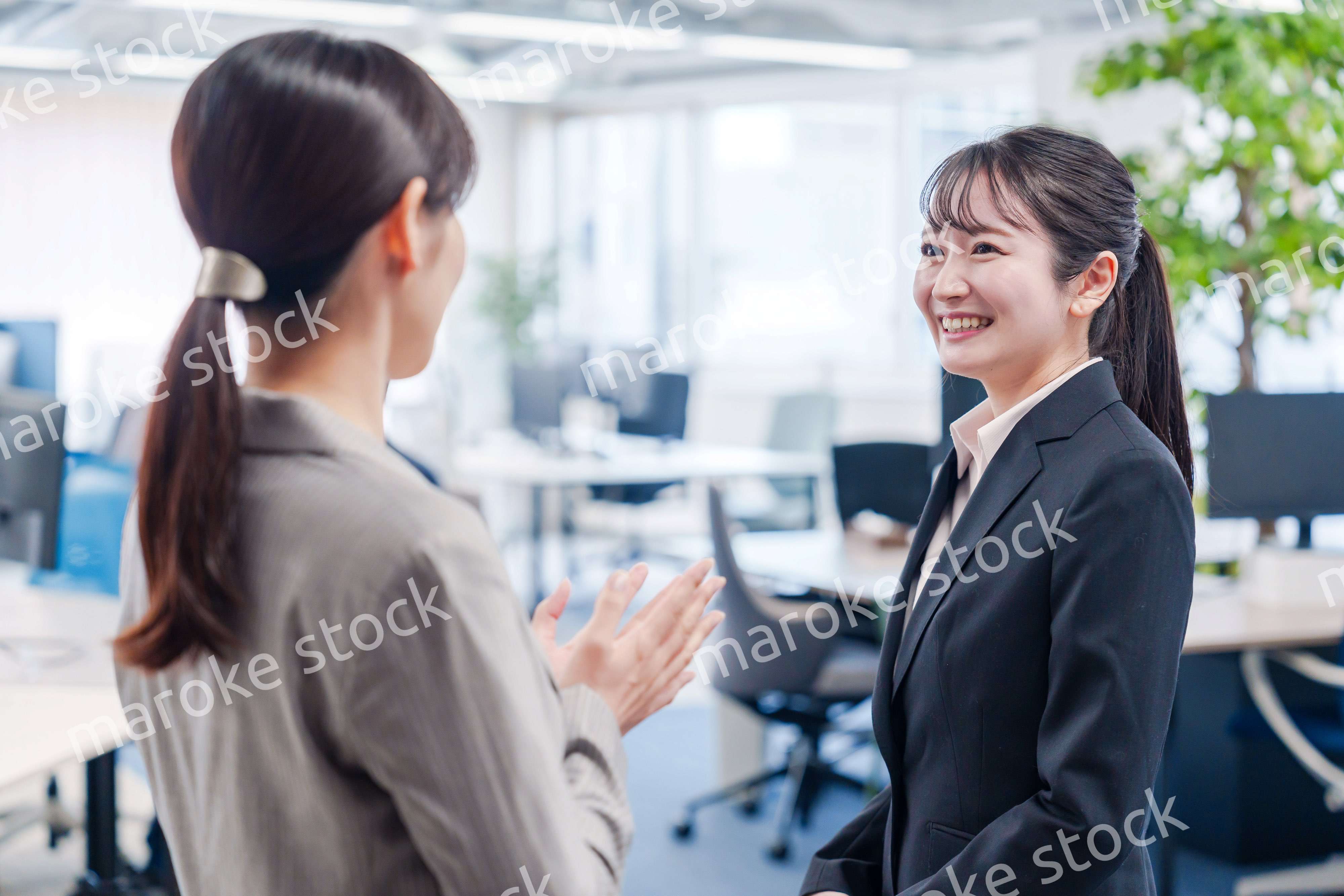 先輩社員にオフィスを案内してもらうフレッシュな女性