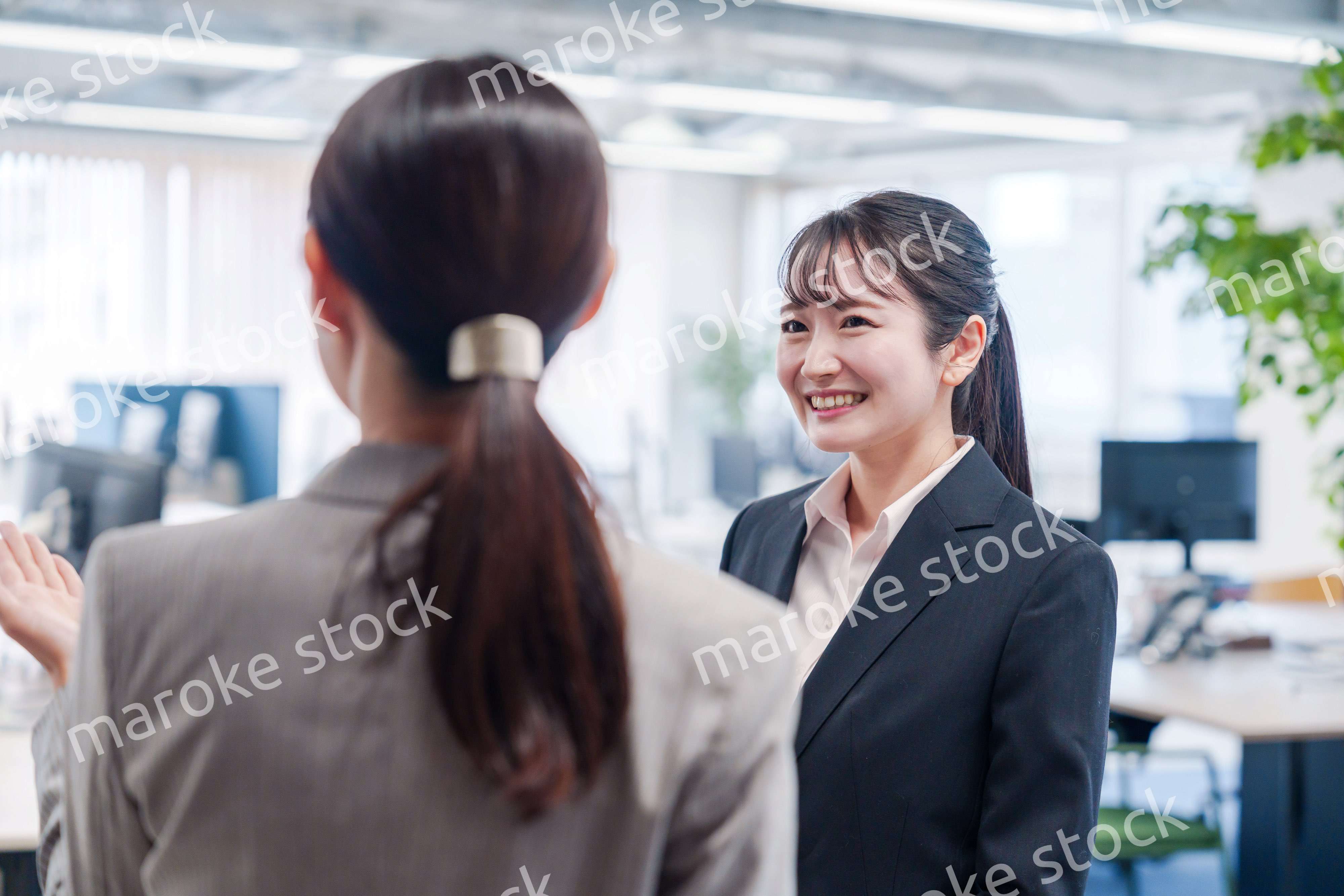 先輩社員にオフィスを案内してもらうフレッシュな女性