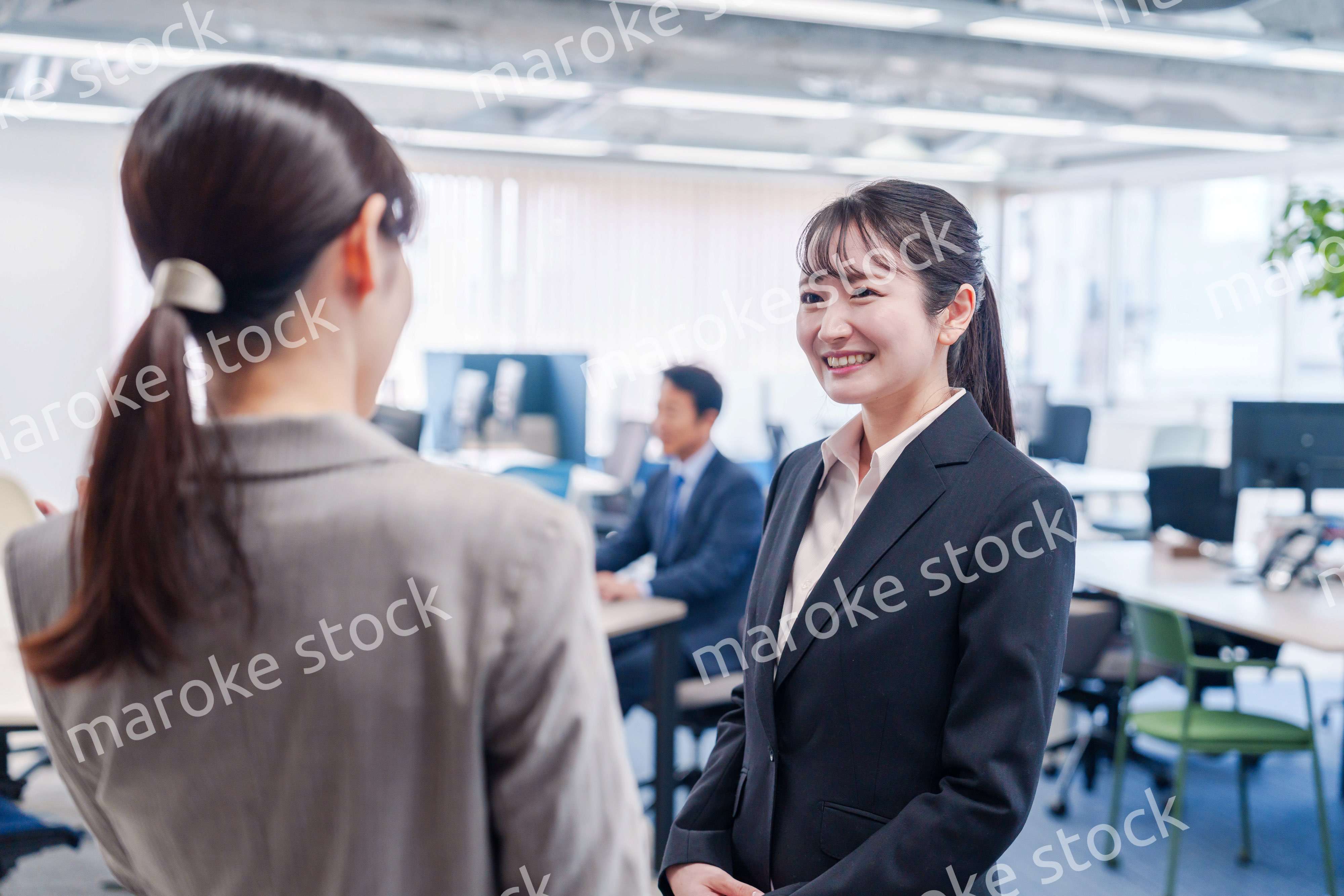 先輩社員にオフィスを案内してもらうフレッシュな女性