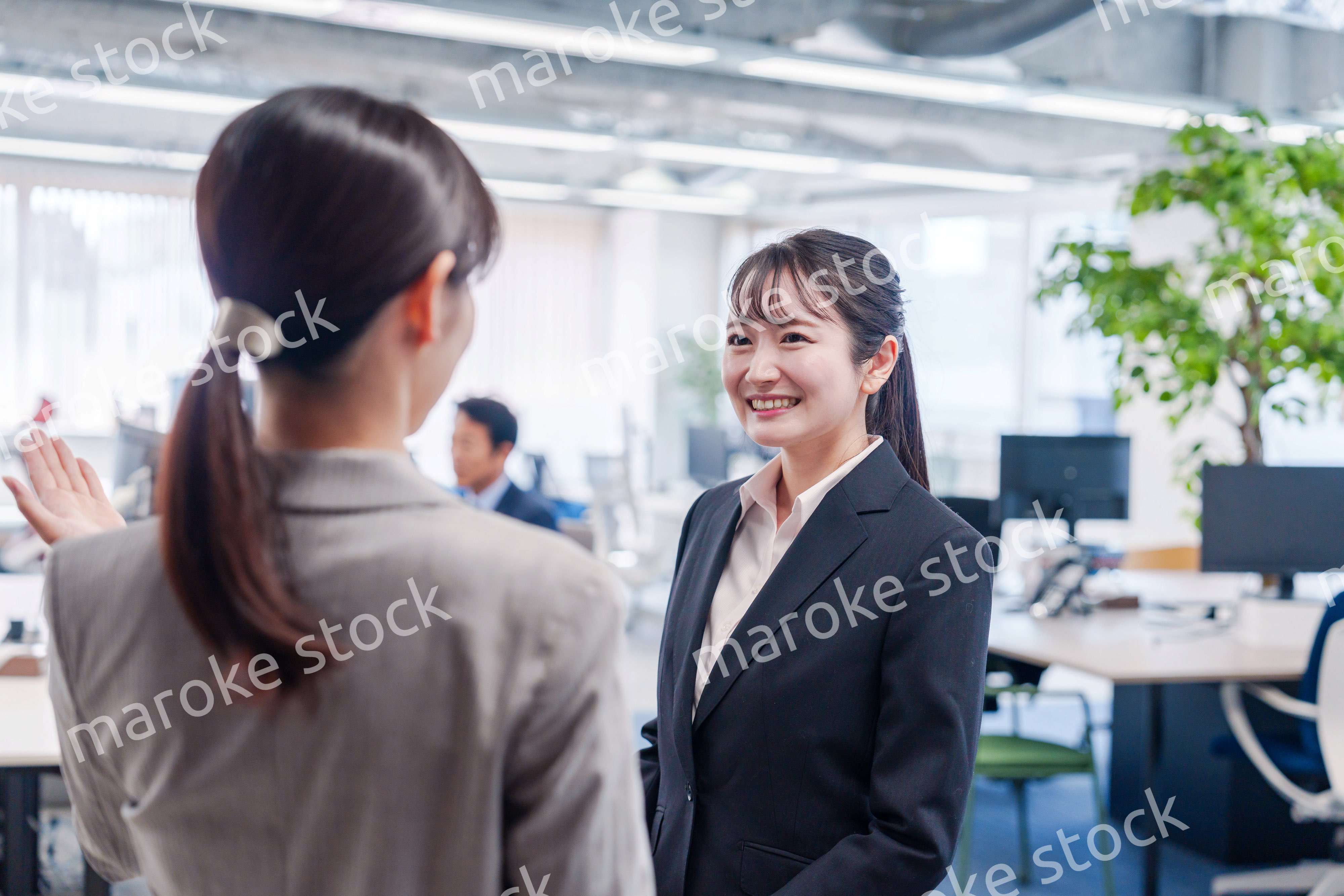 先輩社員にオフィスを案内してもらうフレッシュな女性