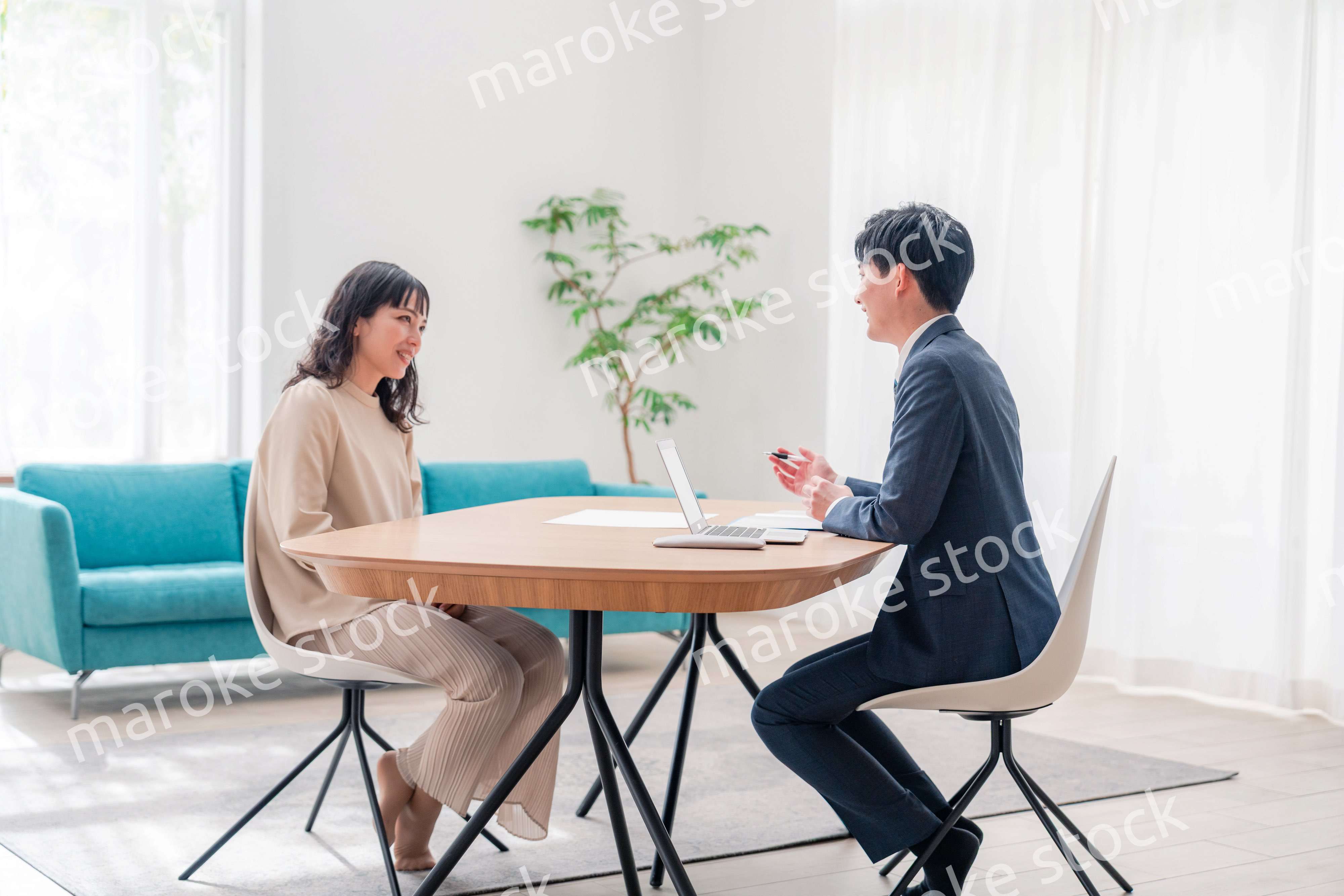 家のリビングを訪問し営業をする男性のビジネスマン