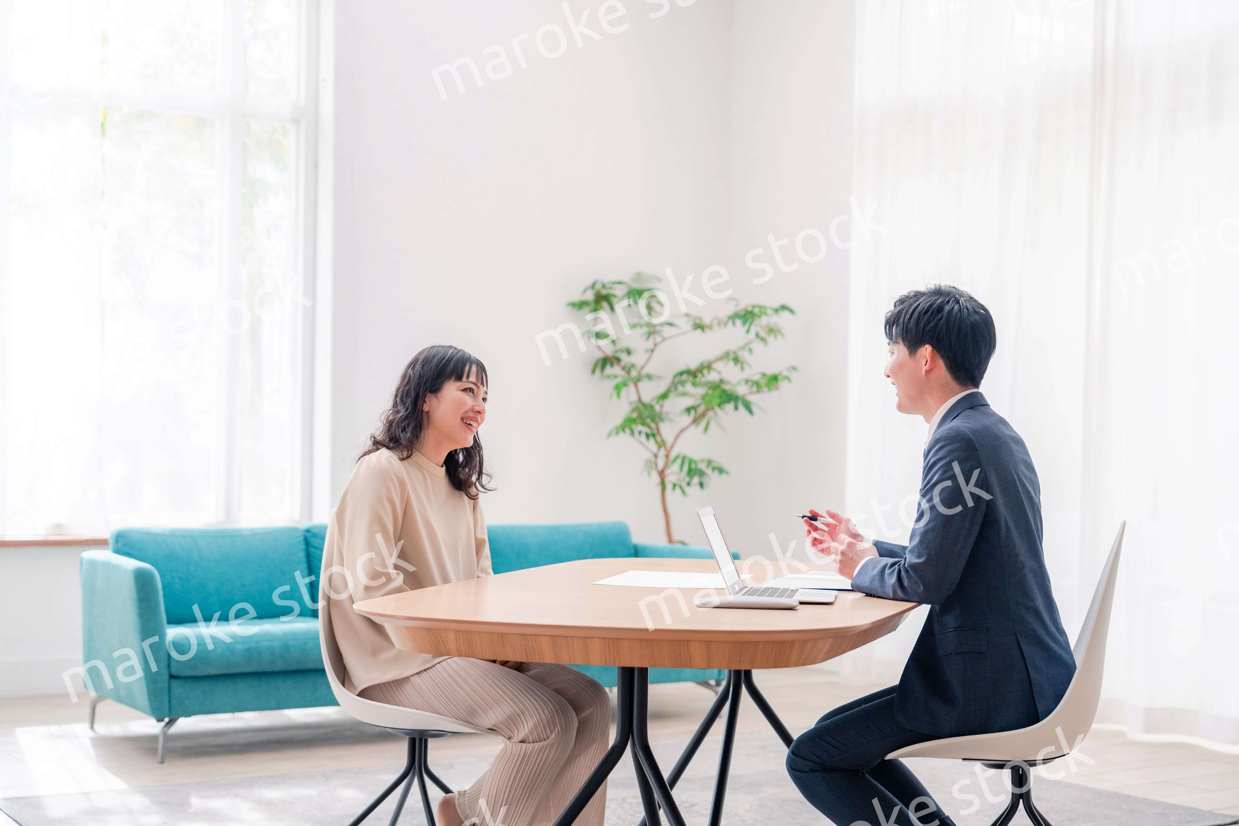 家のリビングを訪問し営業をする男性のビジネスマン