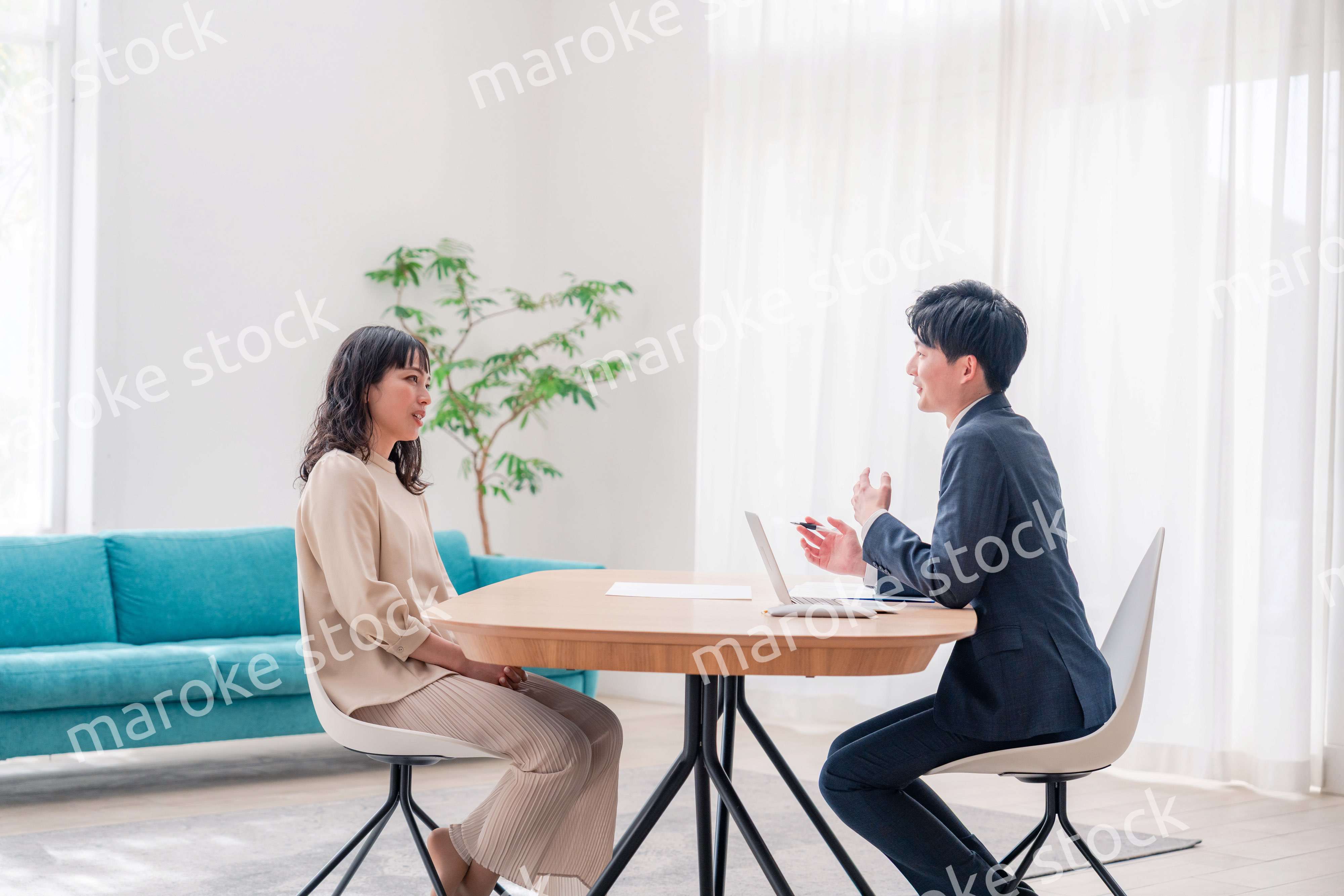 家のリビングを訪問し営業をする男性のビジネスマン