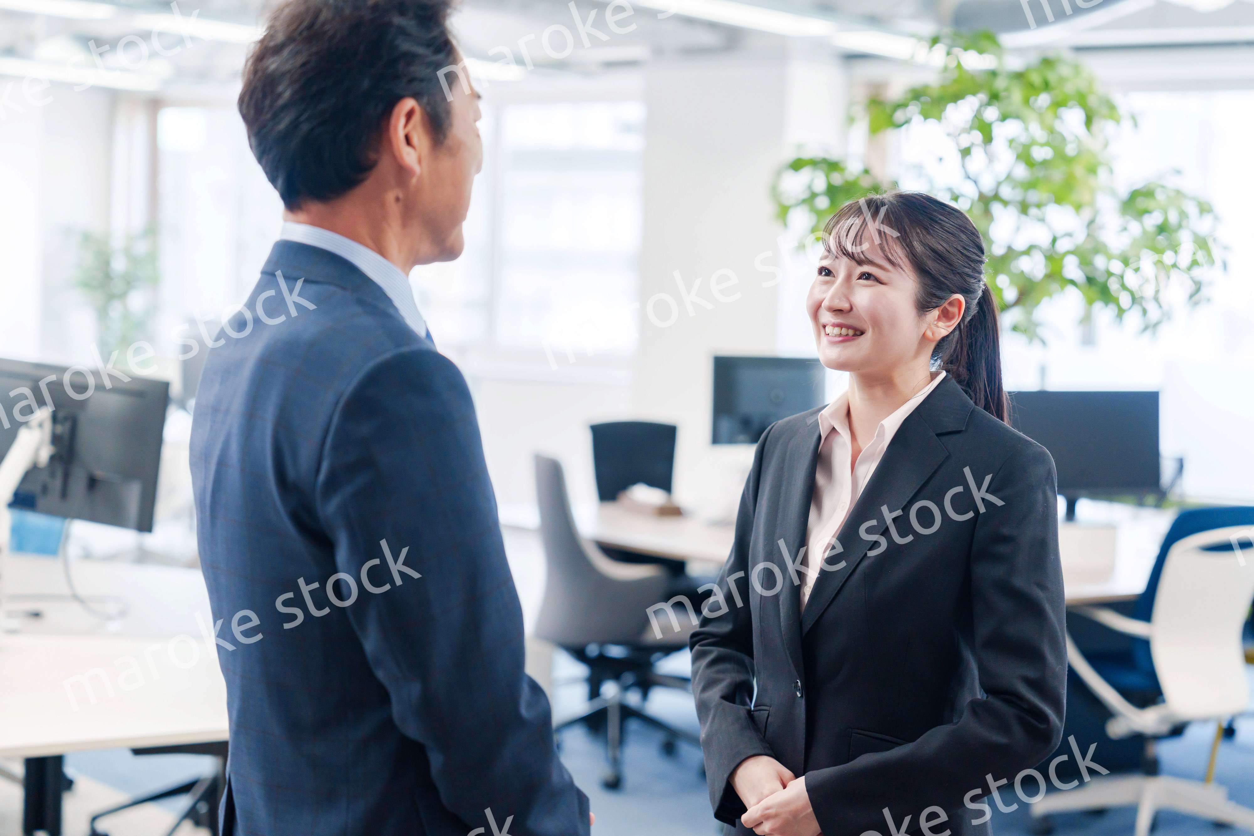 笑顔で上司と話をする若いビジネスウーマン