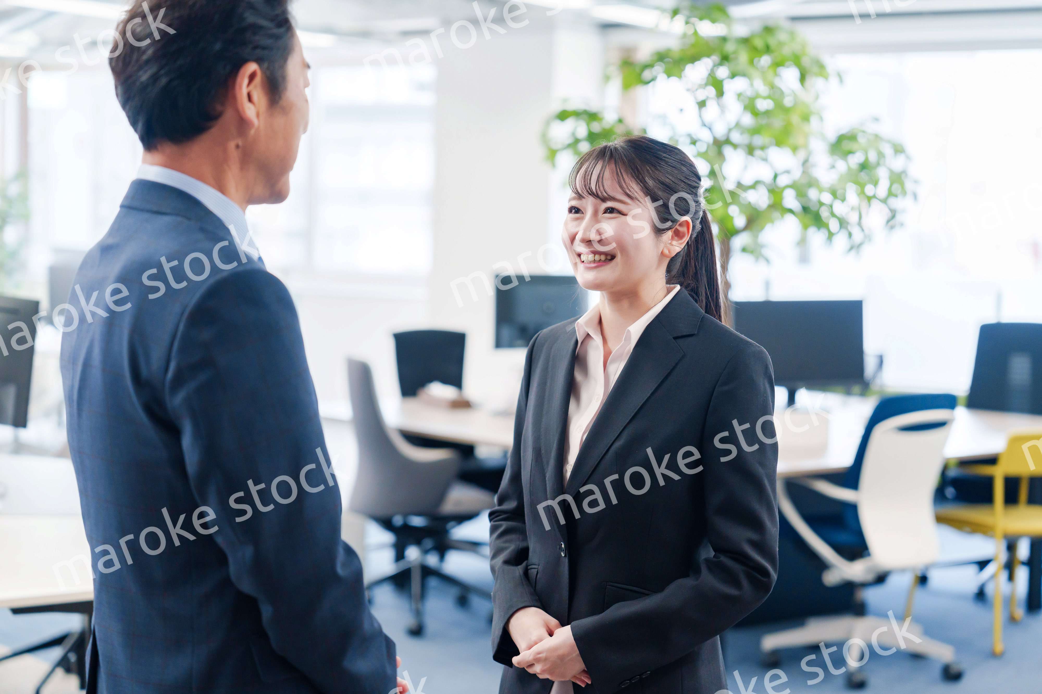 笑顔で上司と話をする若いビジネスウーマン