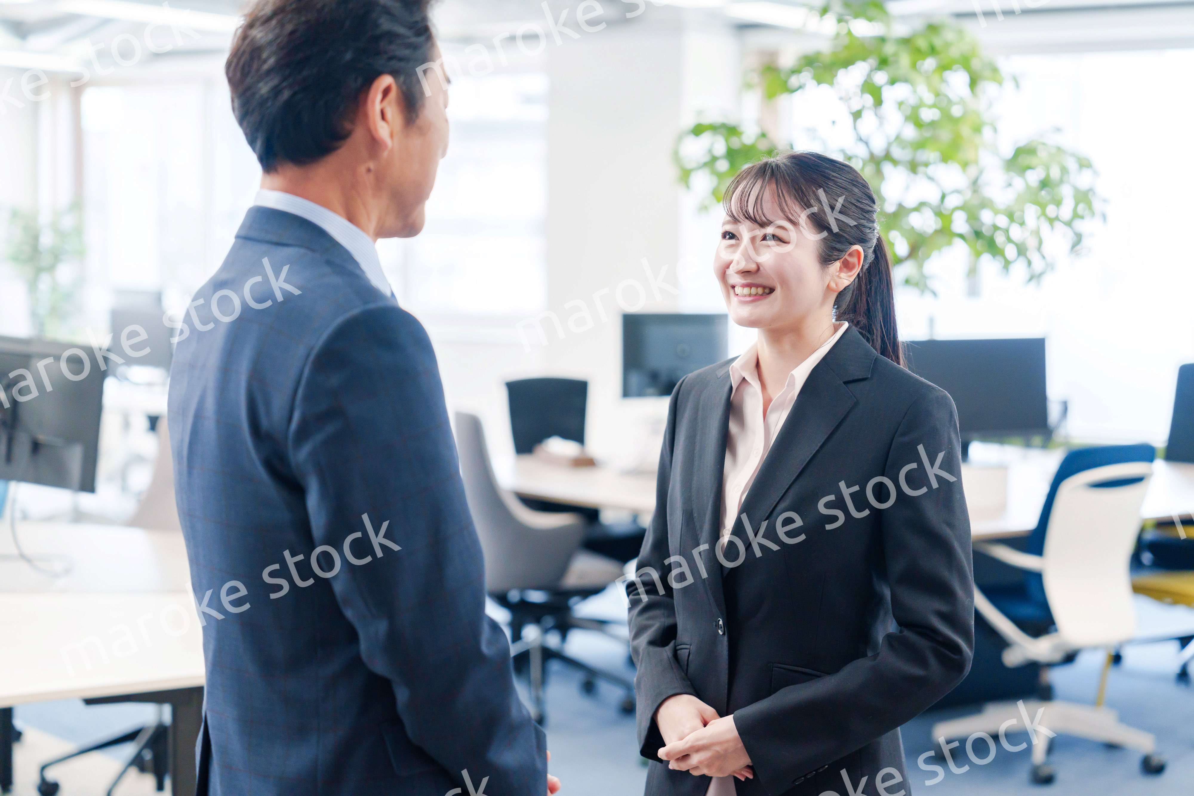 笑顔で上司と話をする若いビジネスウーマン