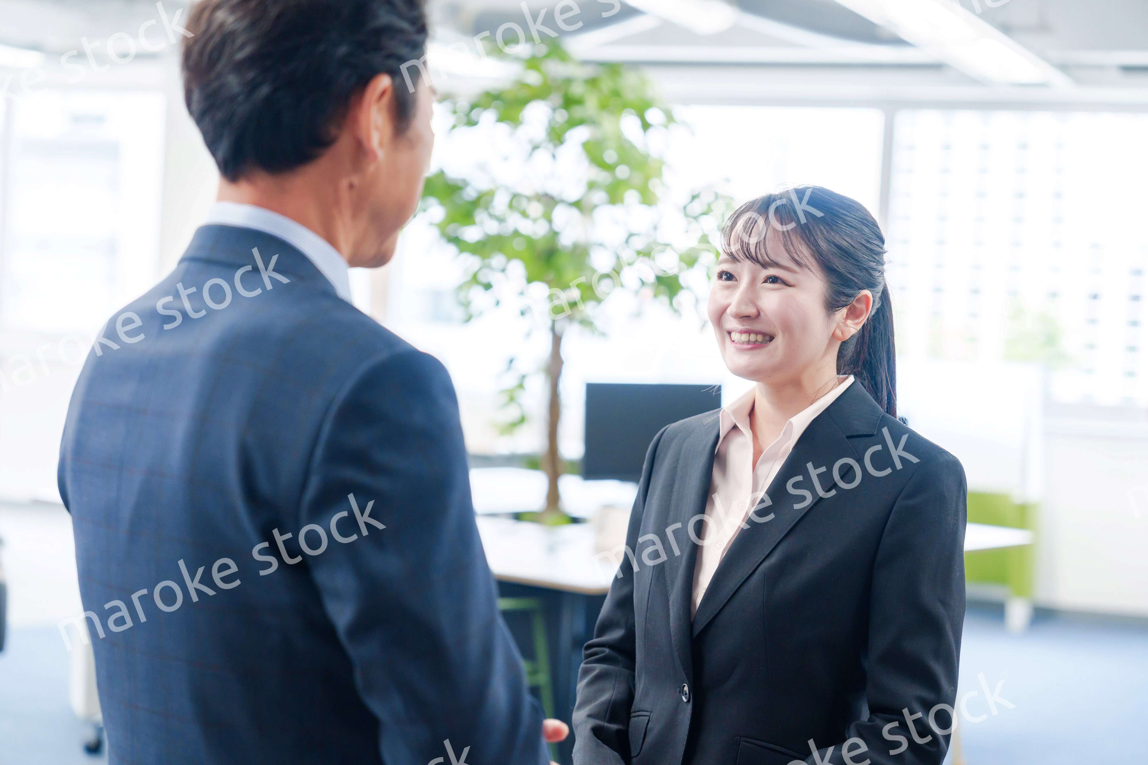 笑顔で上司と話をする若いビジネスウーマン