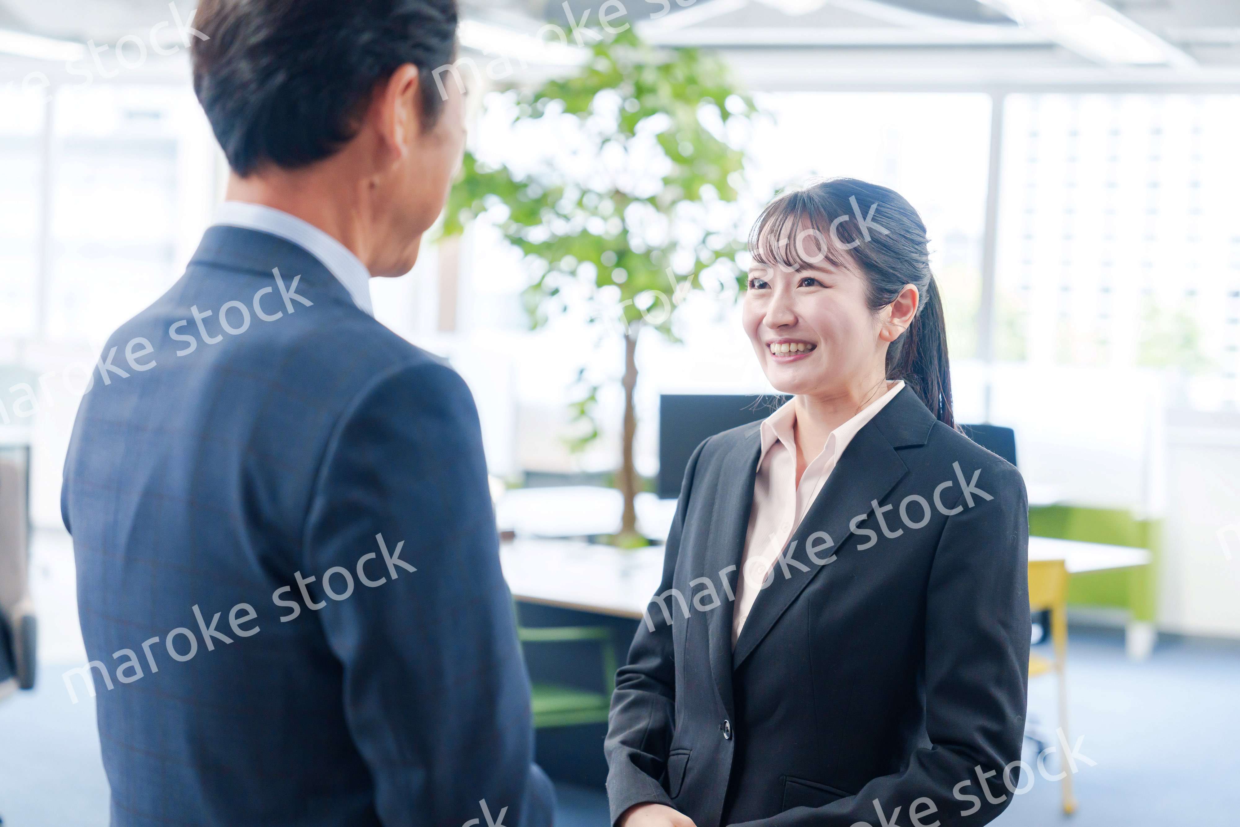 笑顔で上司と話をする若いビジネスウーマン