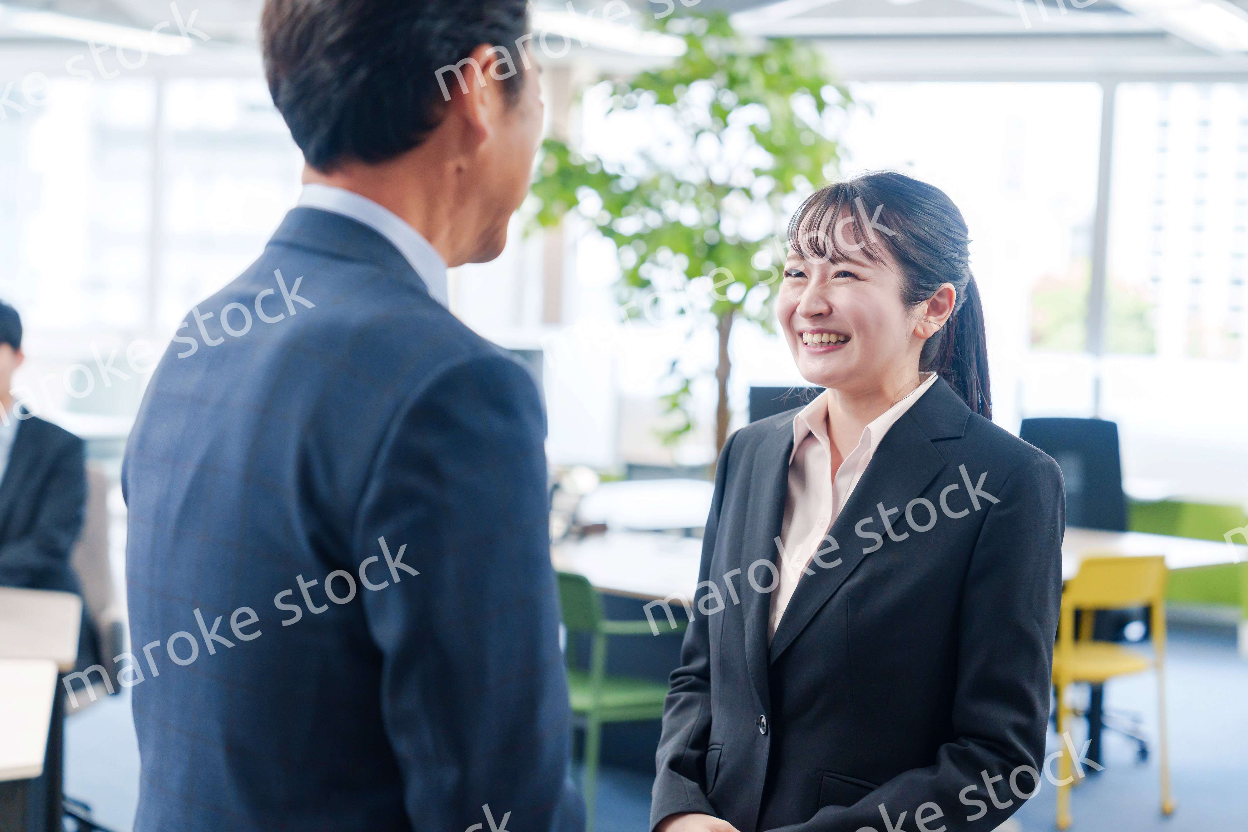 笑顔で上司と話をする若いビジネスウーマン