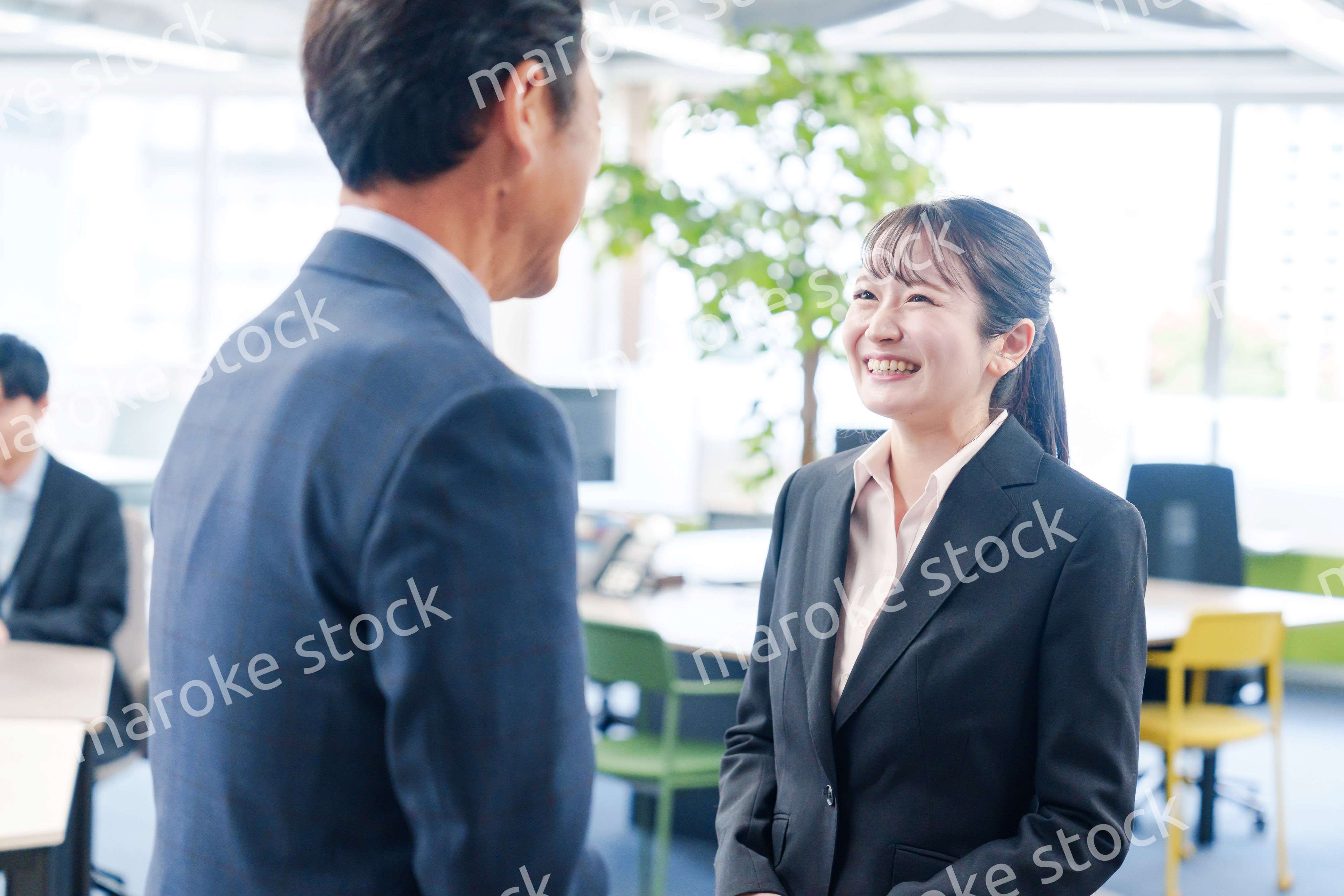 笑顔で上司と話をする若いビジネスウーマン