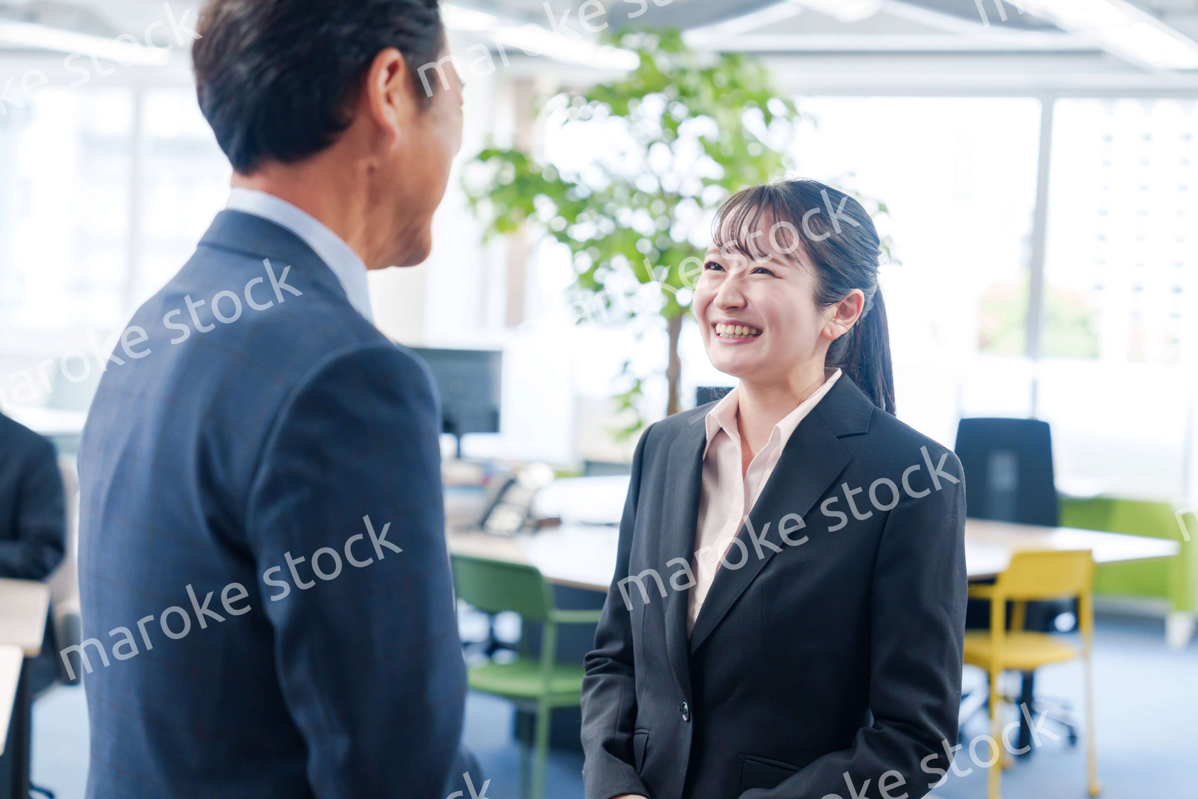 笑顔で上司と話をする若いビジネスウーマン