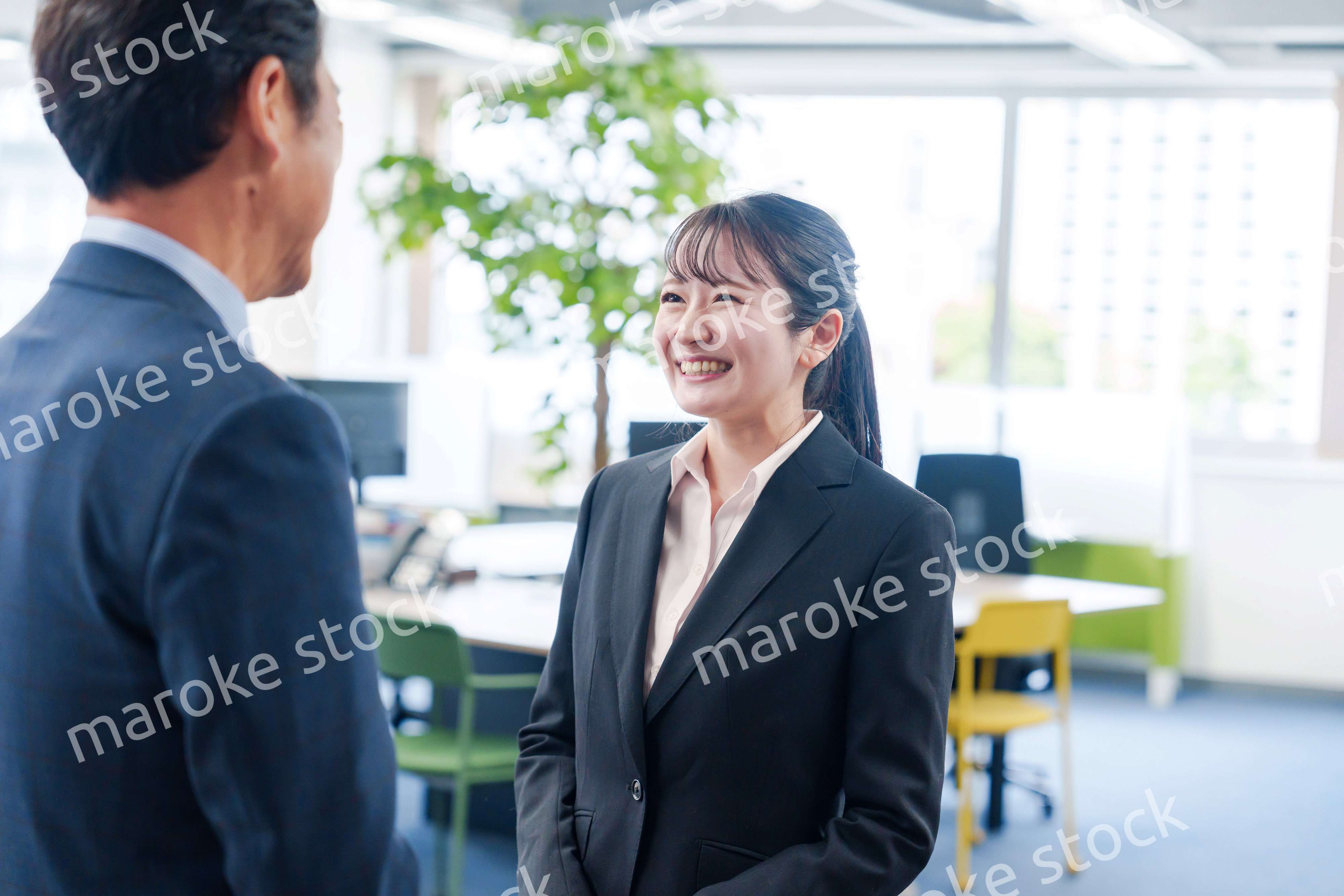 笑顔で上司と話をする若いビジネスウーマン