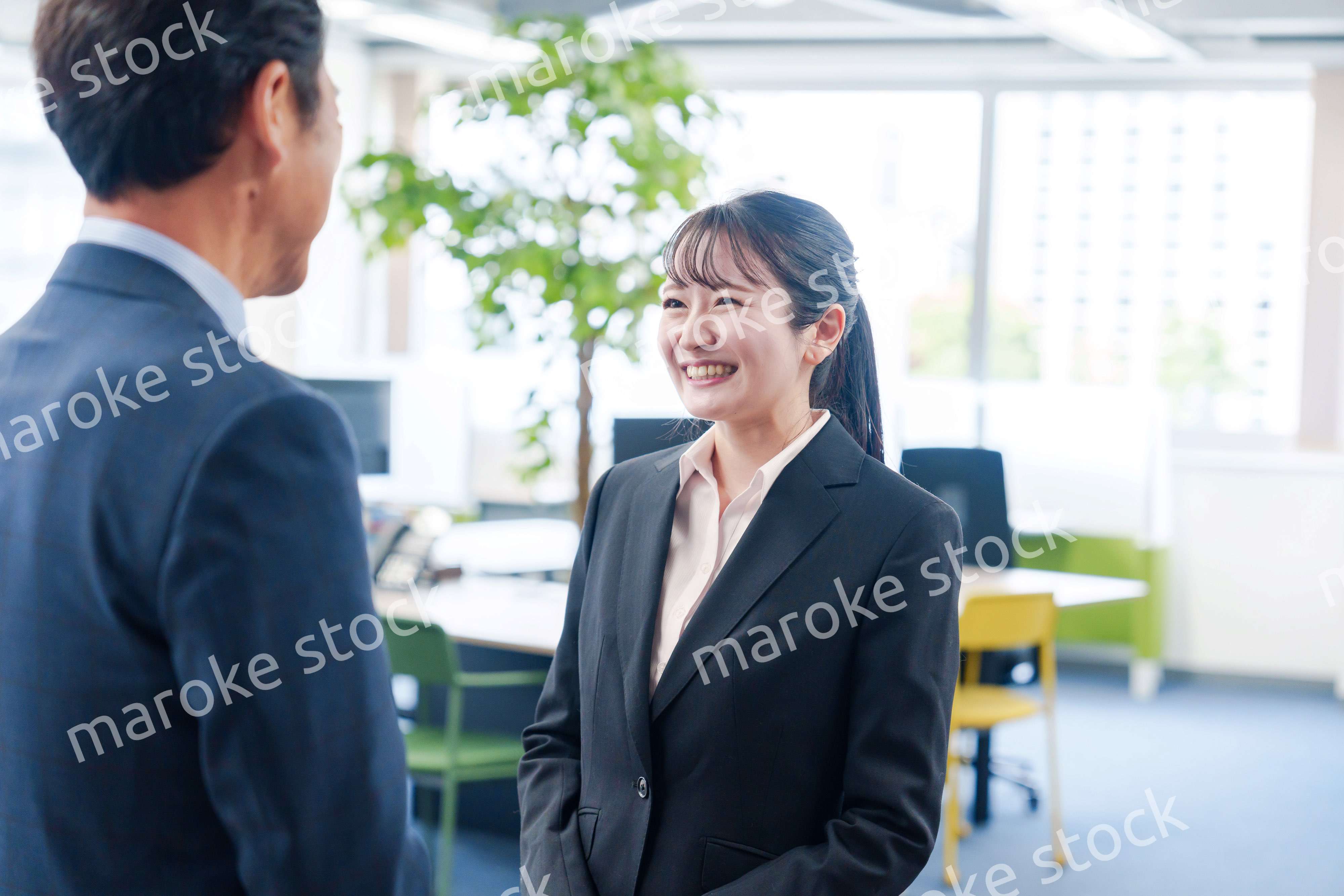 笑顔で上司と話をする若いビジネスウーマン