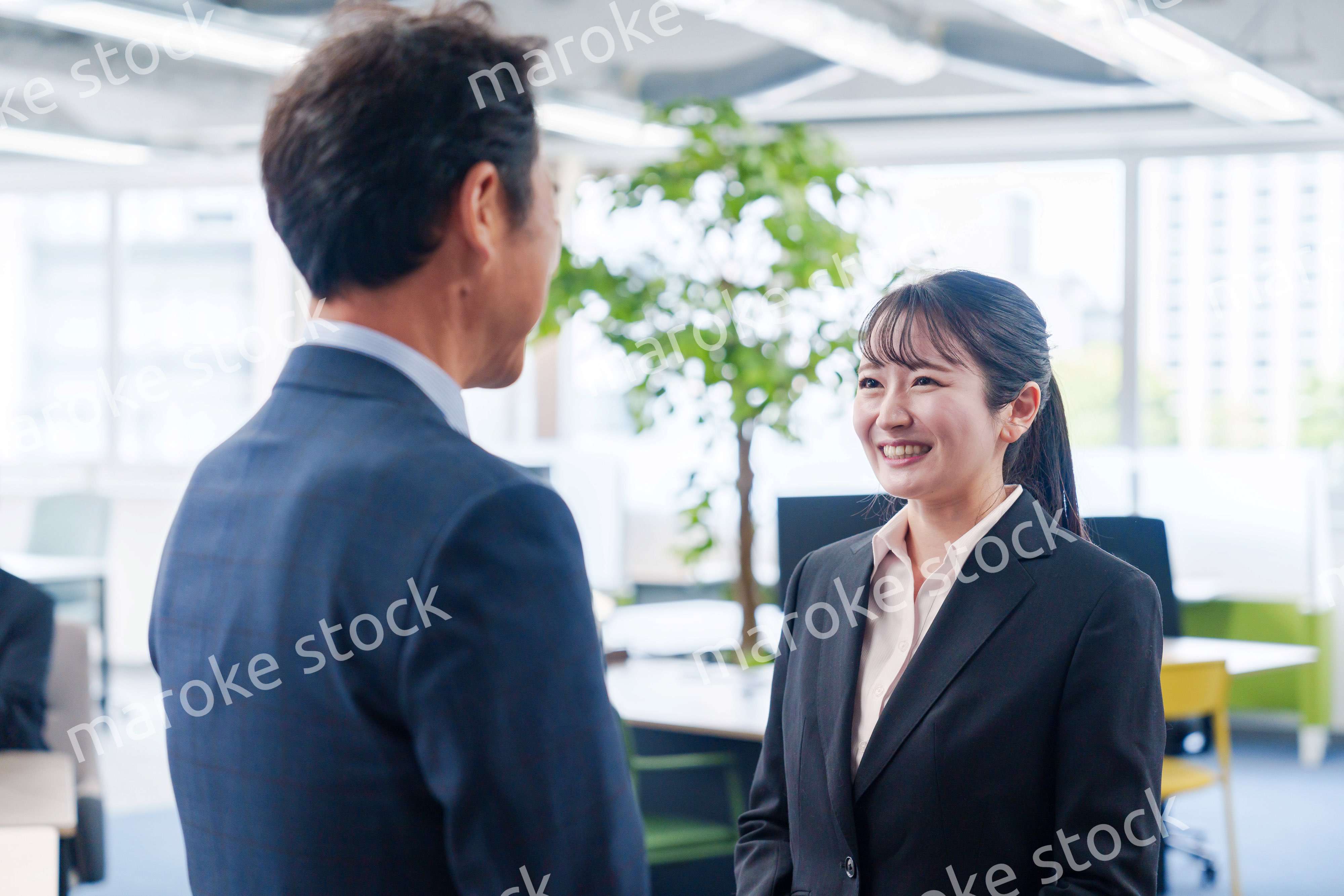 笑顔で上司と話をする若いビジネスウーマン