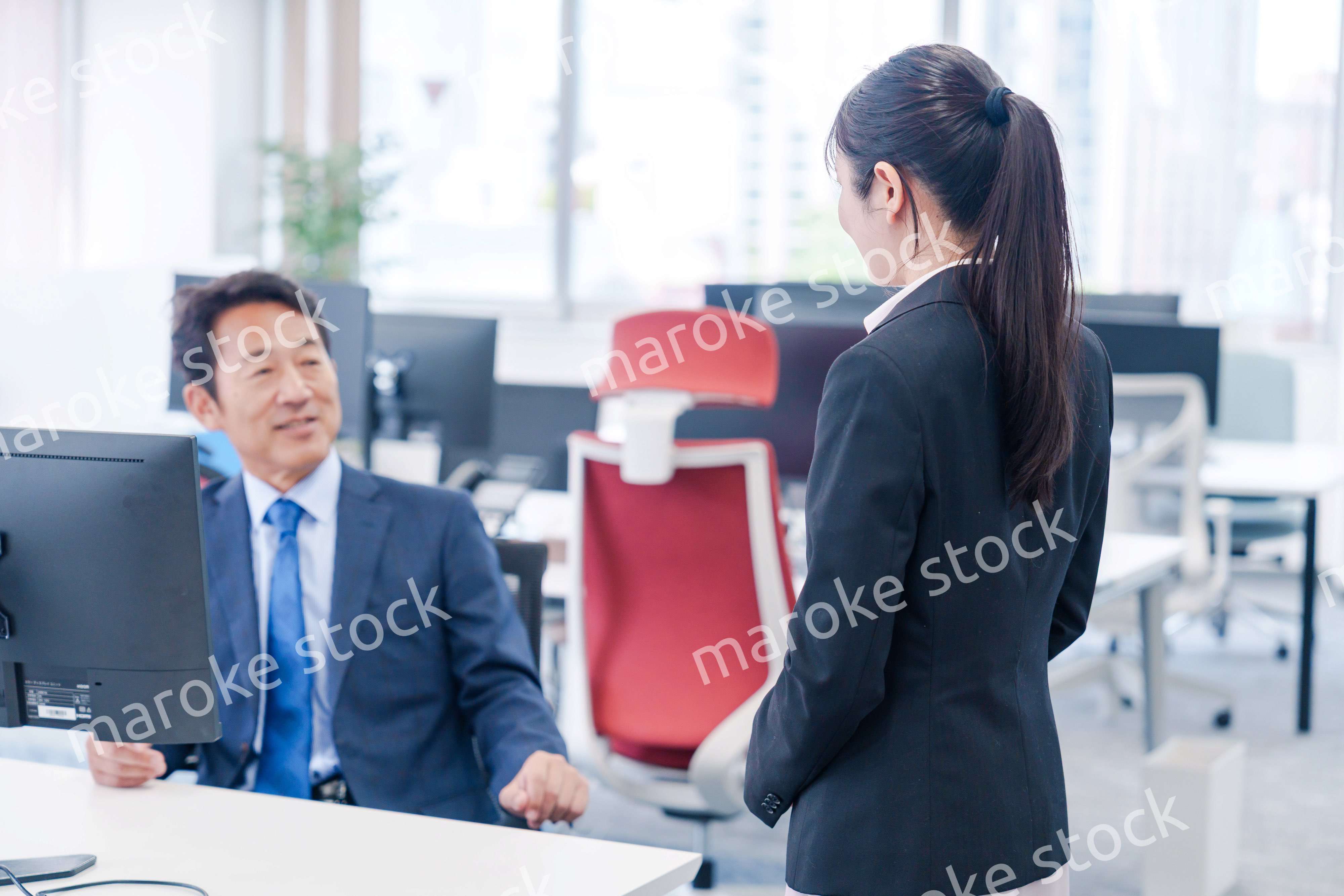 上司に挨拶をする新入社員の女性