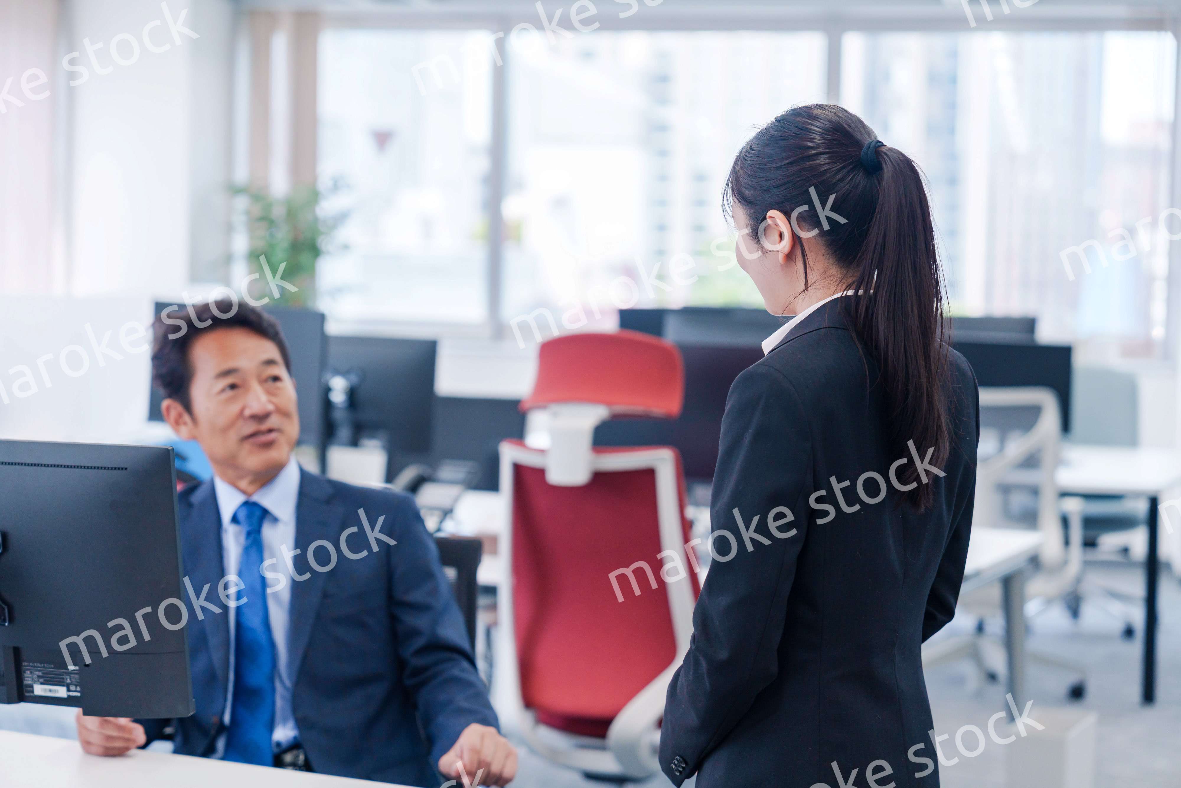 上司に挨拶をする新入社員の女性