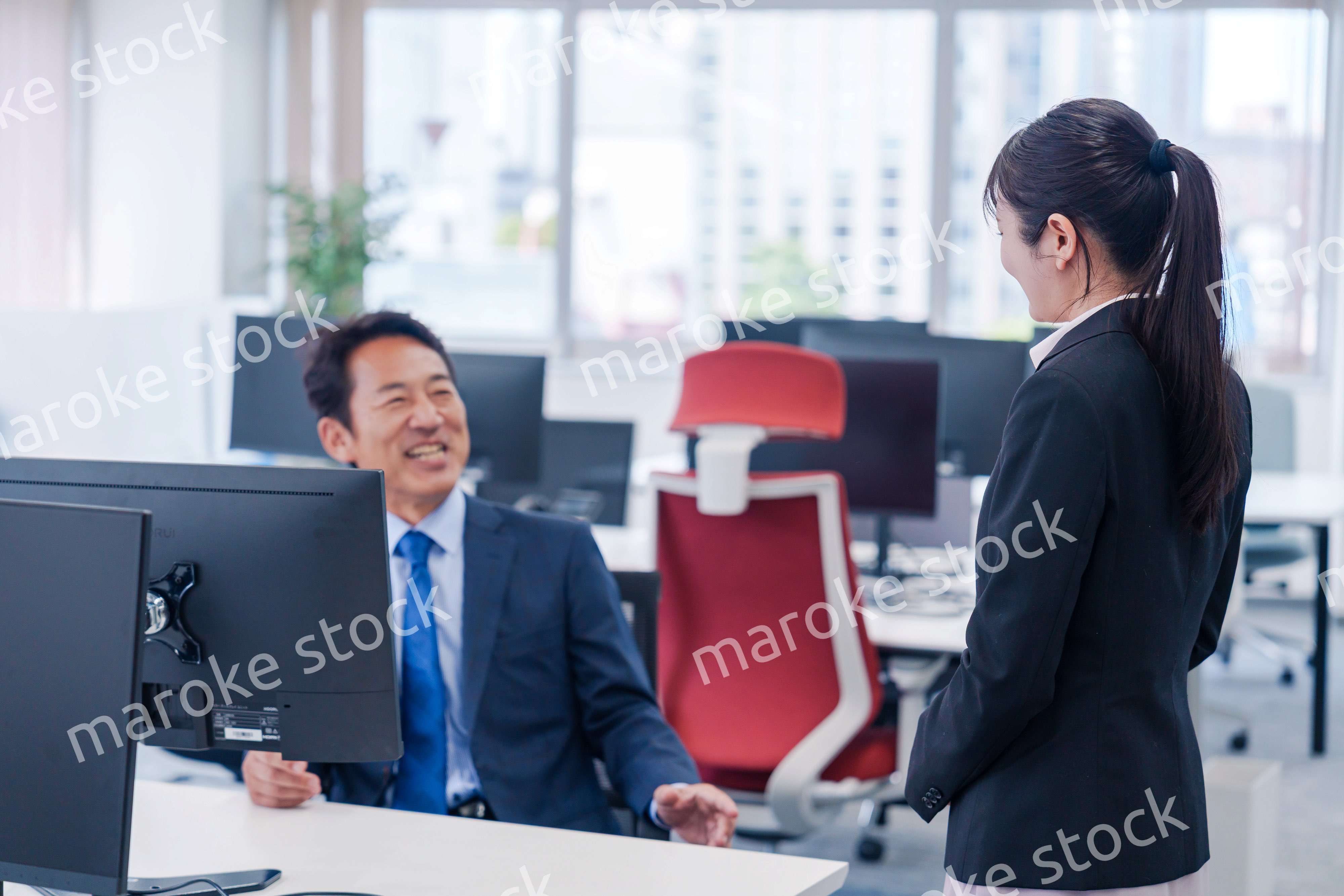 上司に挨拶をする新入社員の女性