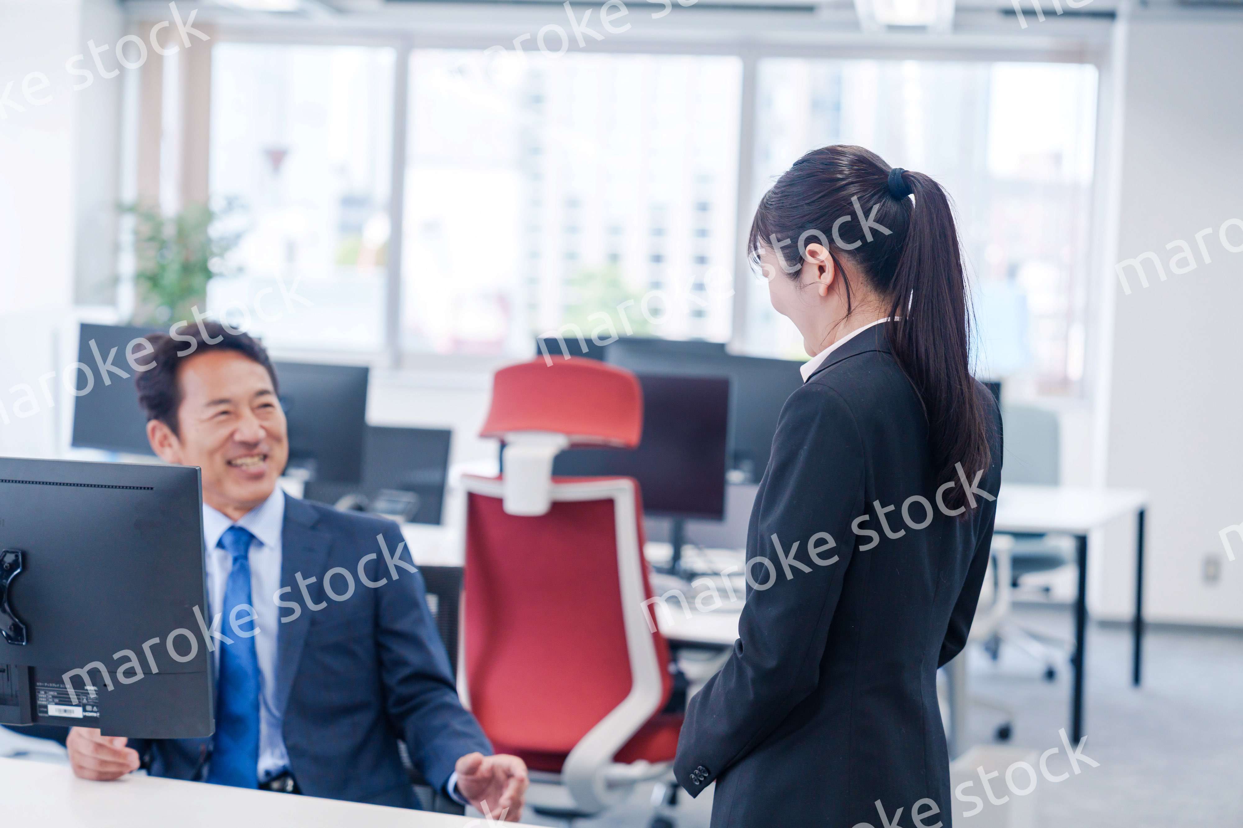 上司に挨拶をする新入社員の女性