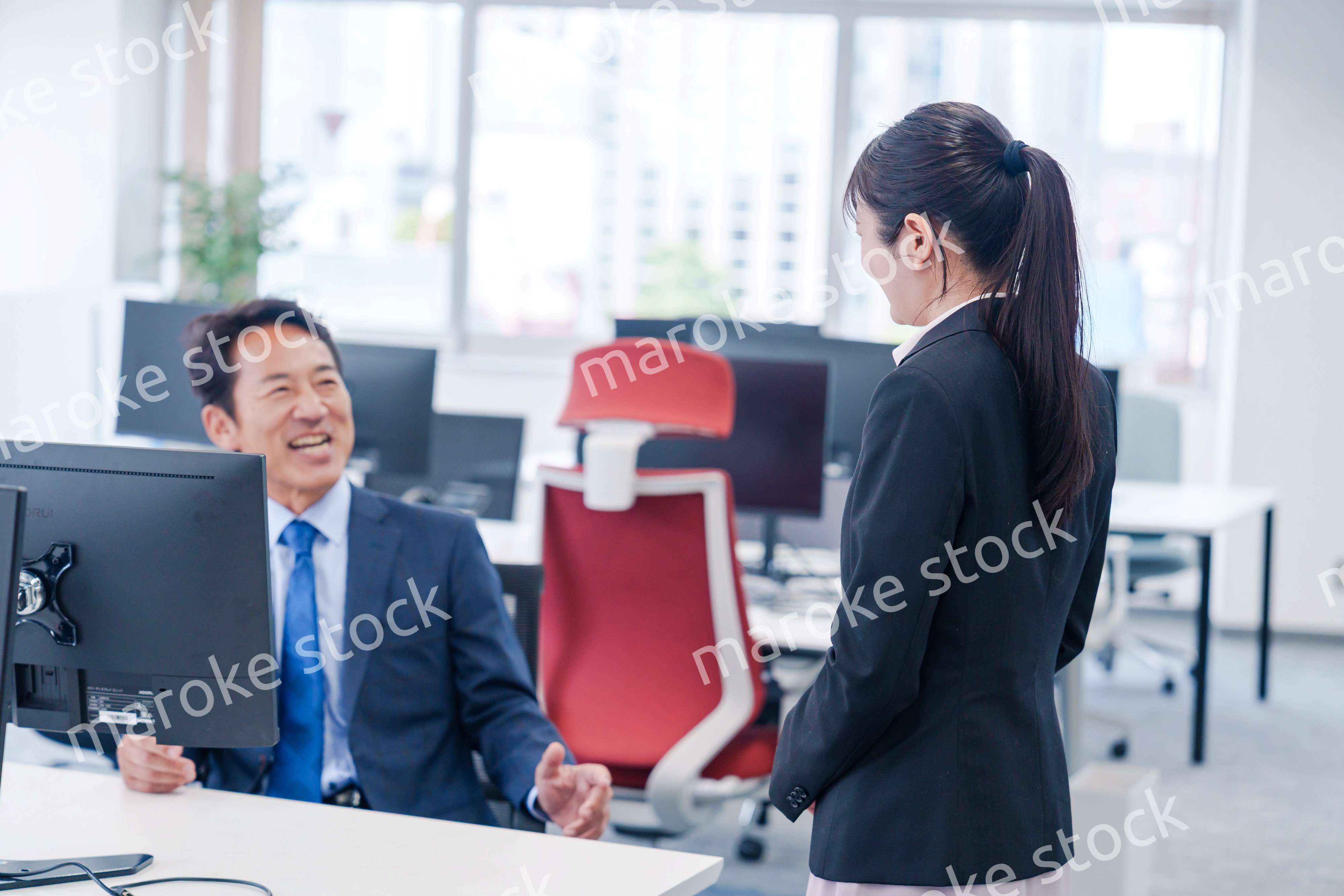 上司に挨拶をする新入社員の女性