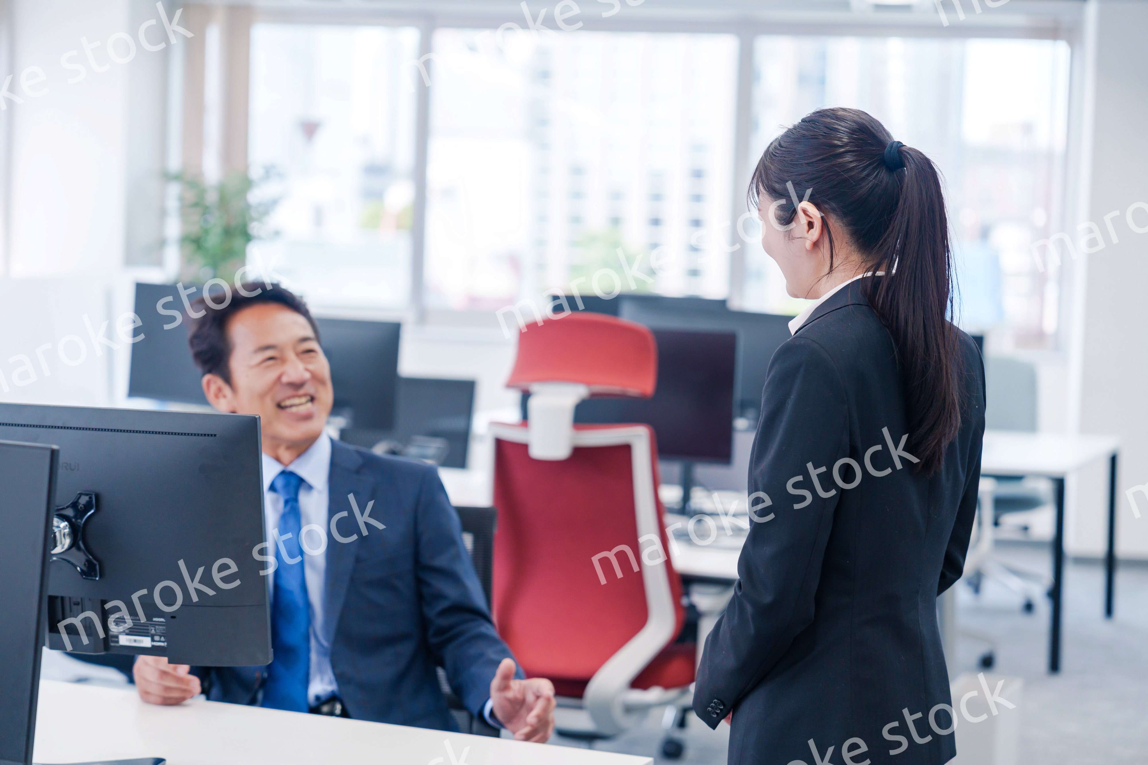 上司に挨拶をする新入社員の女性