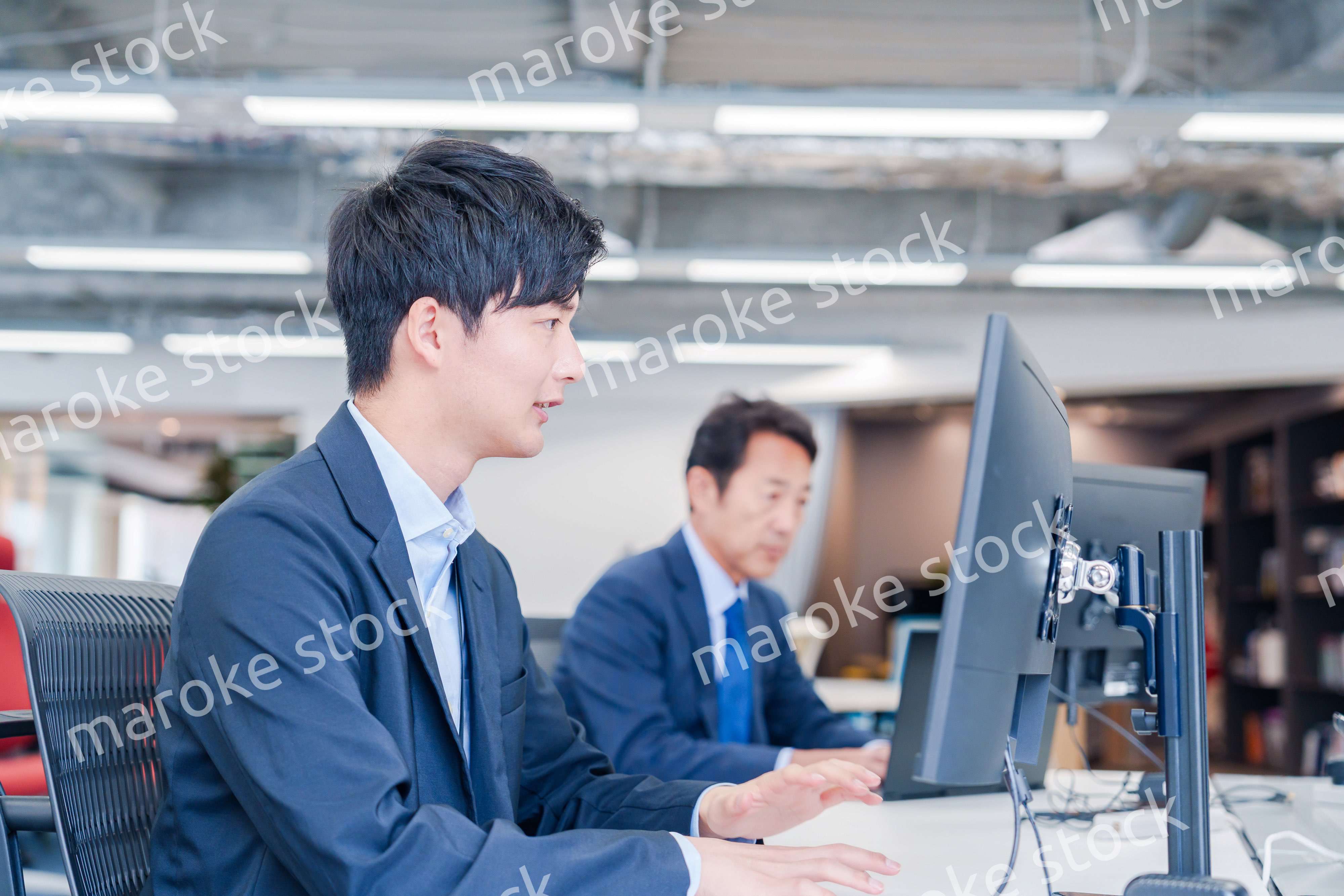 オフィスでモニタに向かって働くビジネスマン