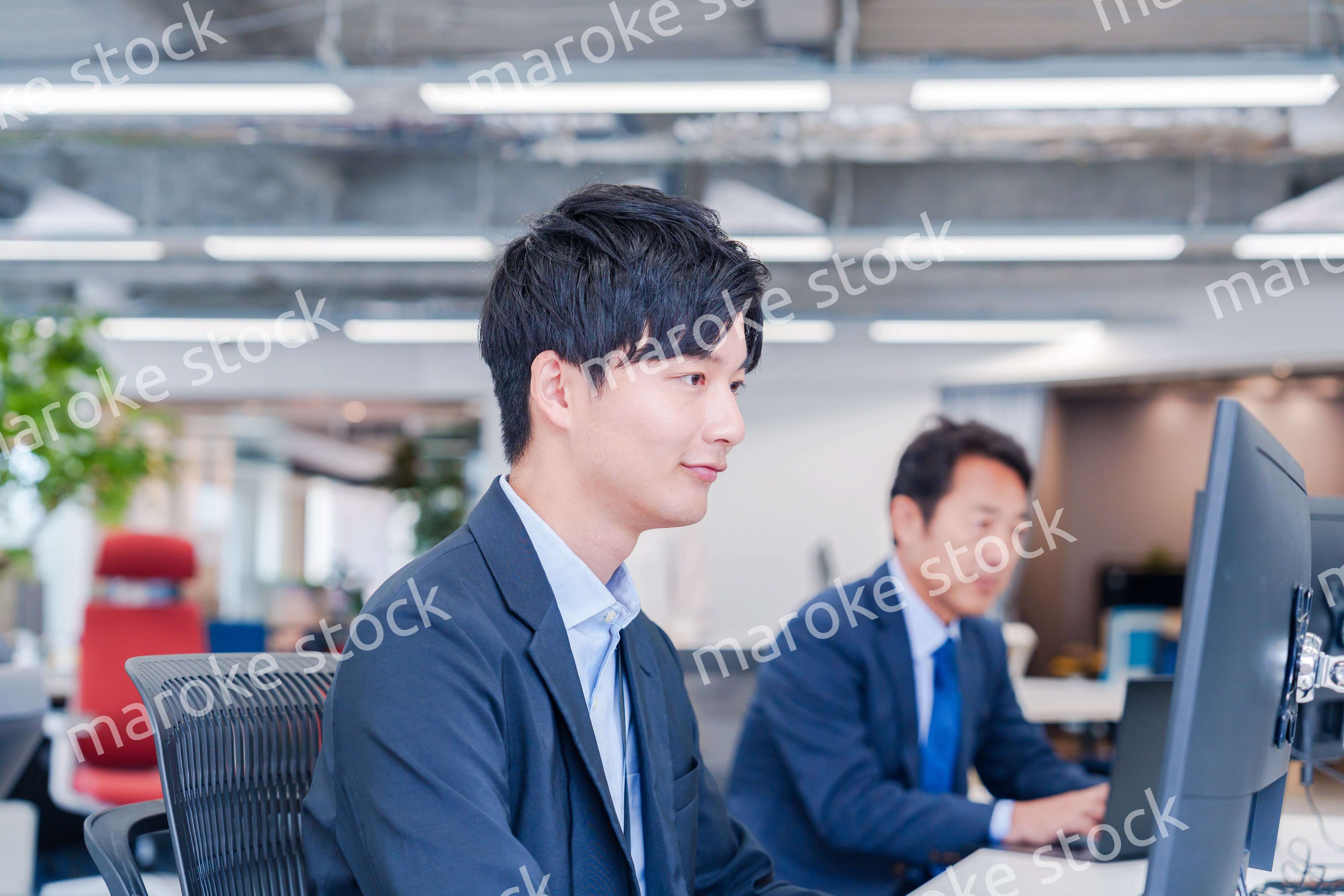 オフィスでモニタに向かって働くビジネスマン