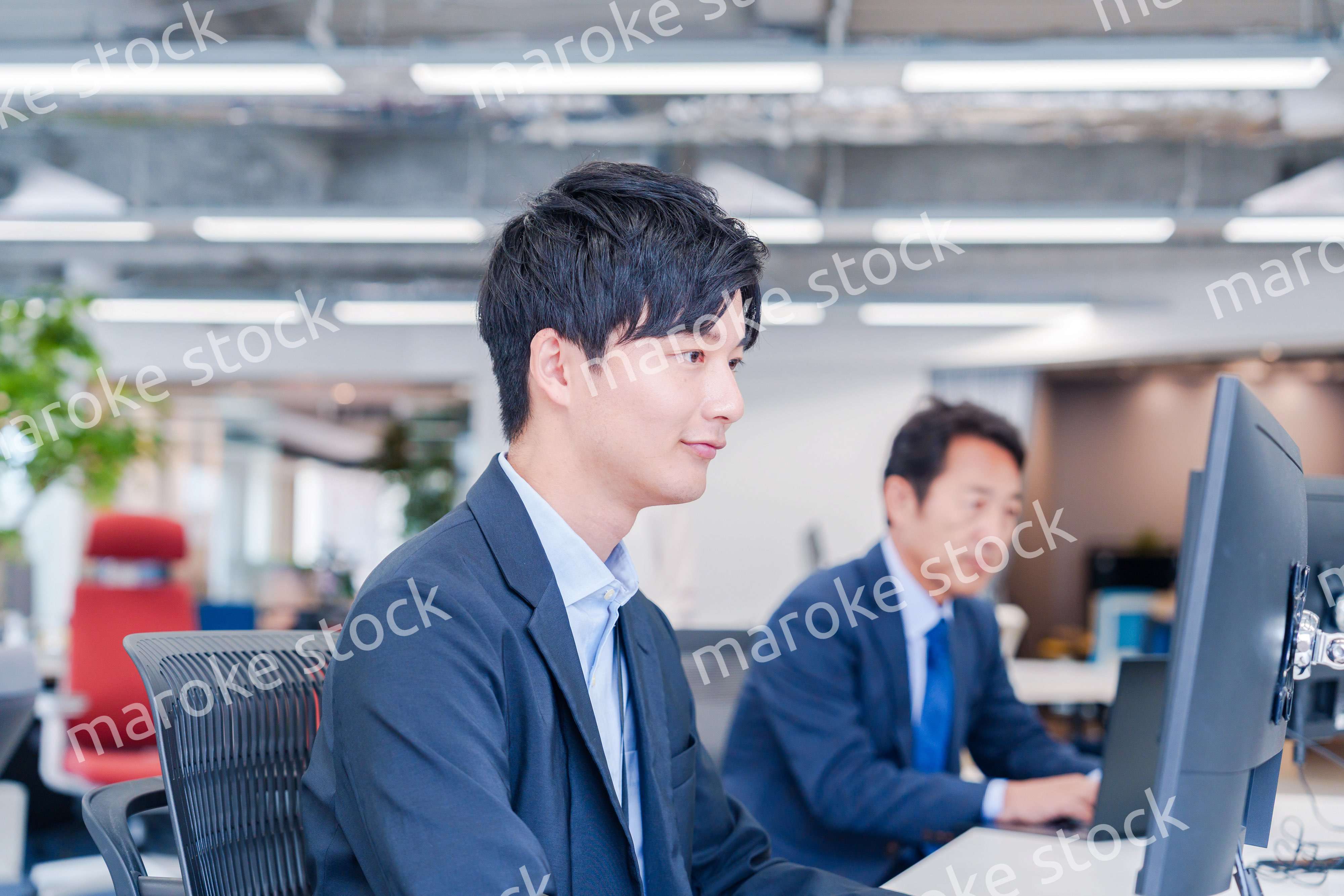 オフィスでモニタに向かって働くビジネスマン