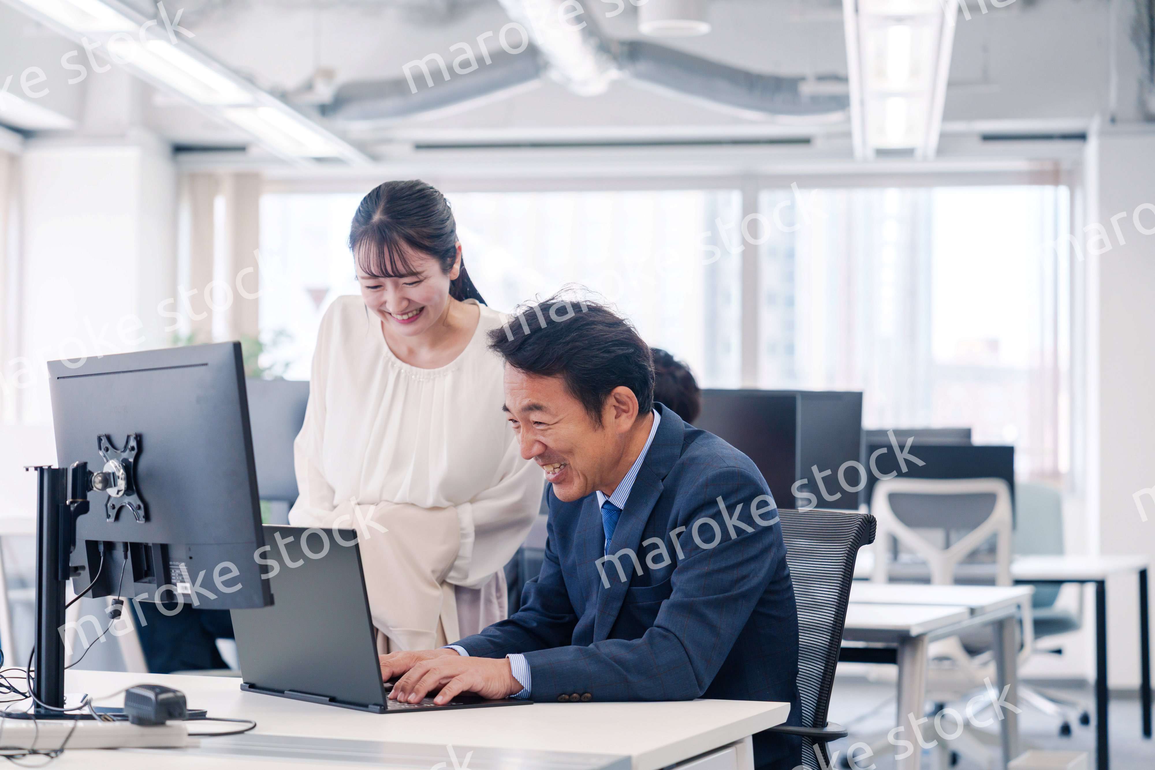 オフィスで盛り上がる上司と若手女性