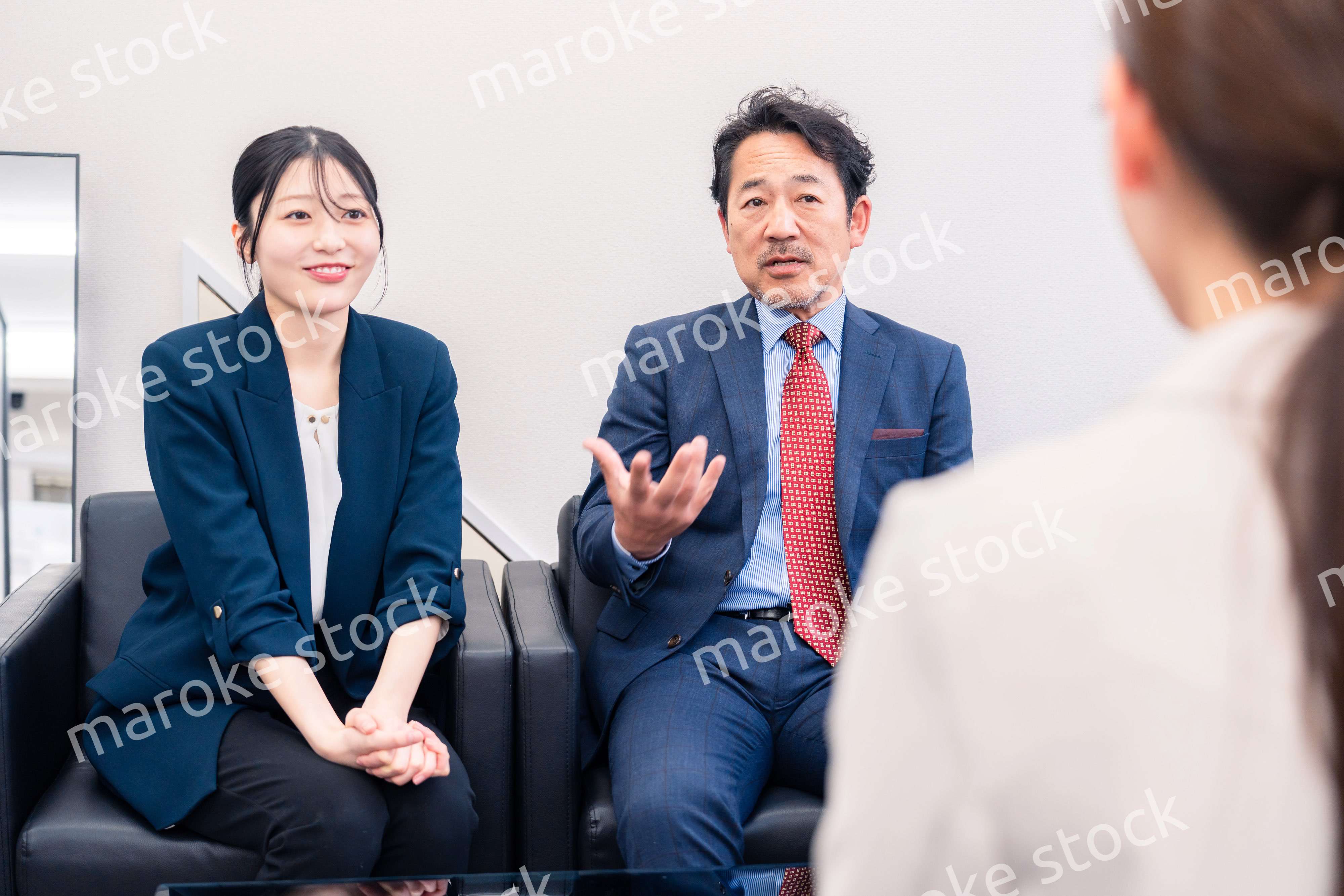 オフィスで楽しく会話をする中年男性とビジネスウーマン