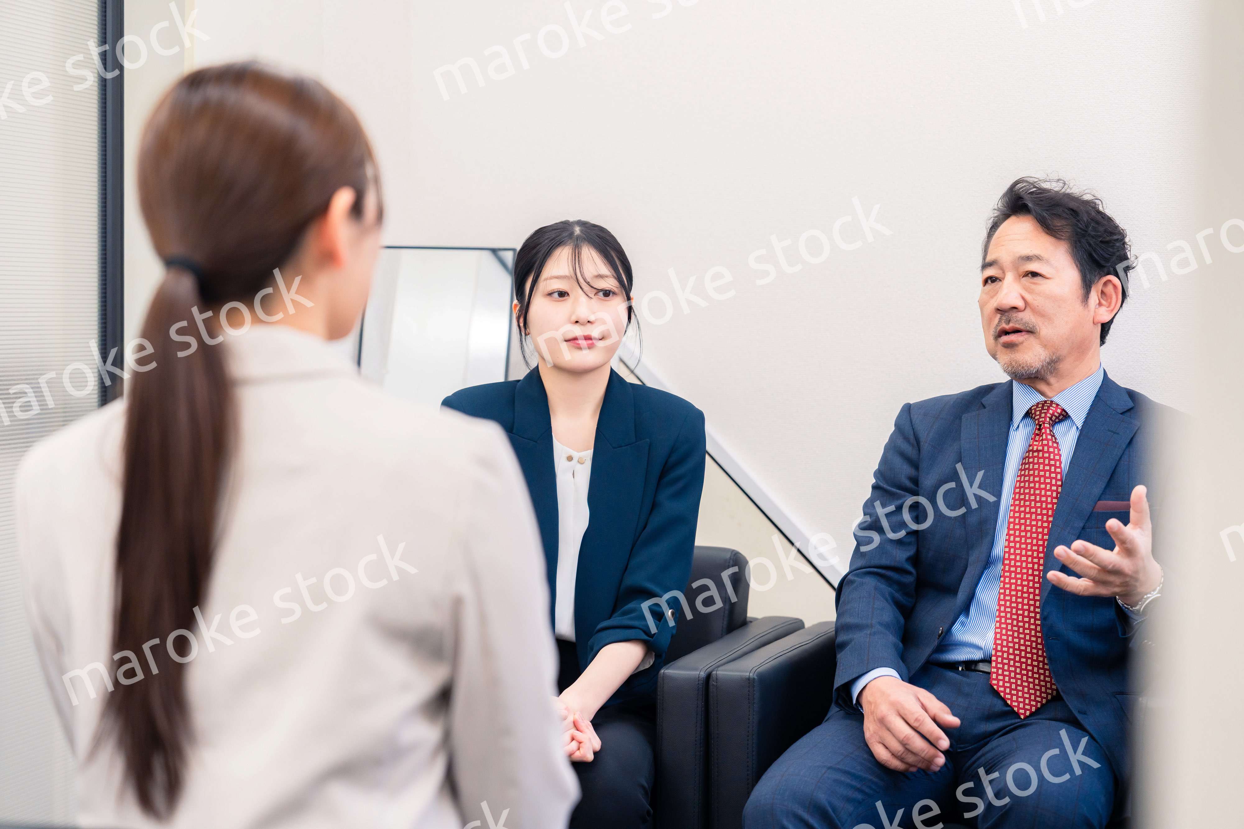 オフィスで楽しく会話をする中年男性とビジネスウーマン