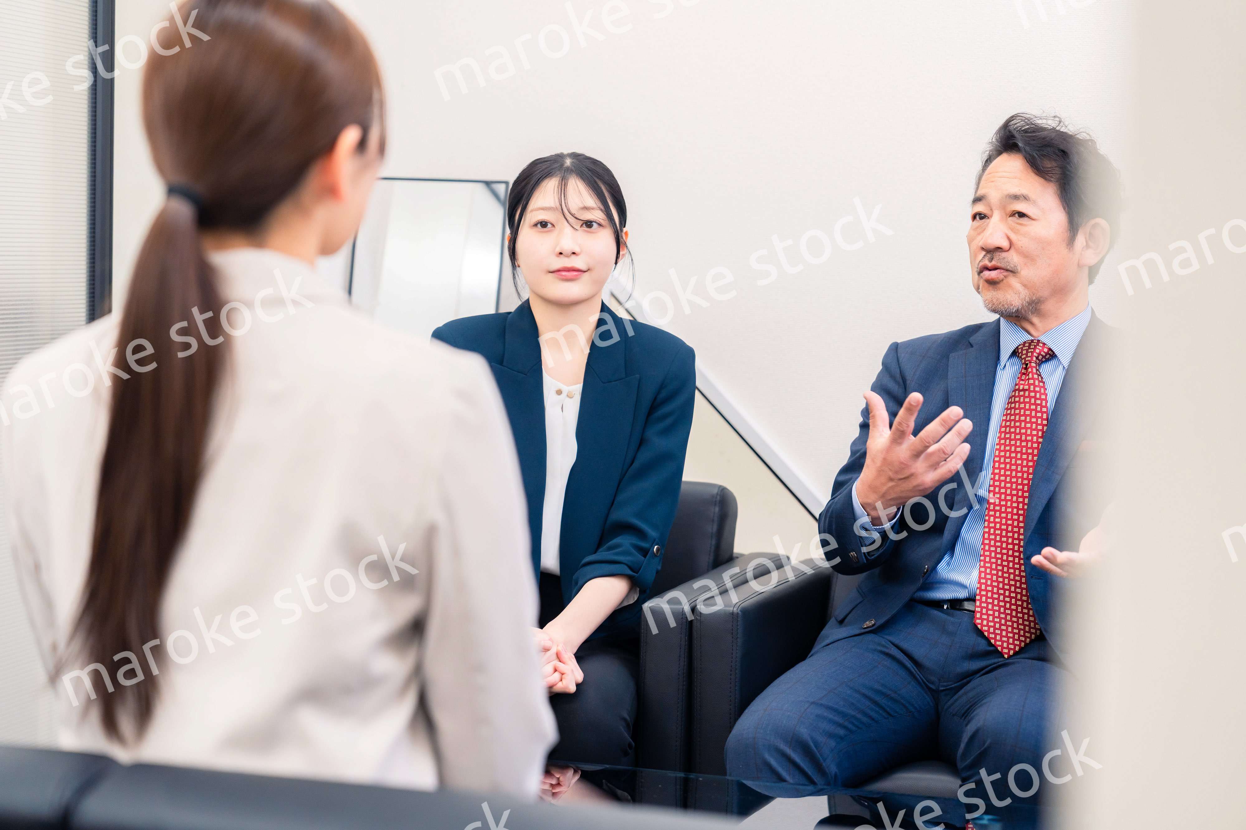 オフィスで楽しく会話をする中年男性とビジネスウーマン