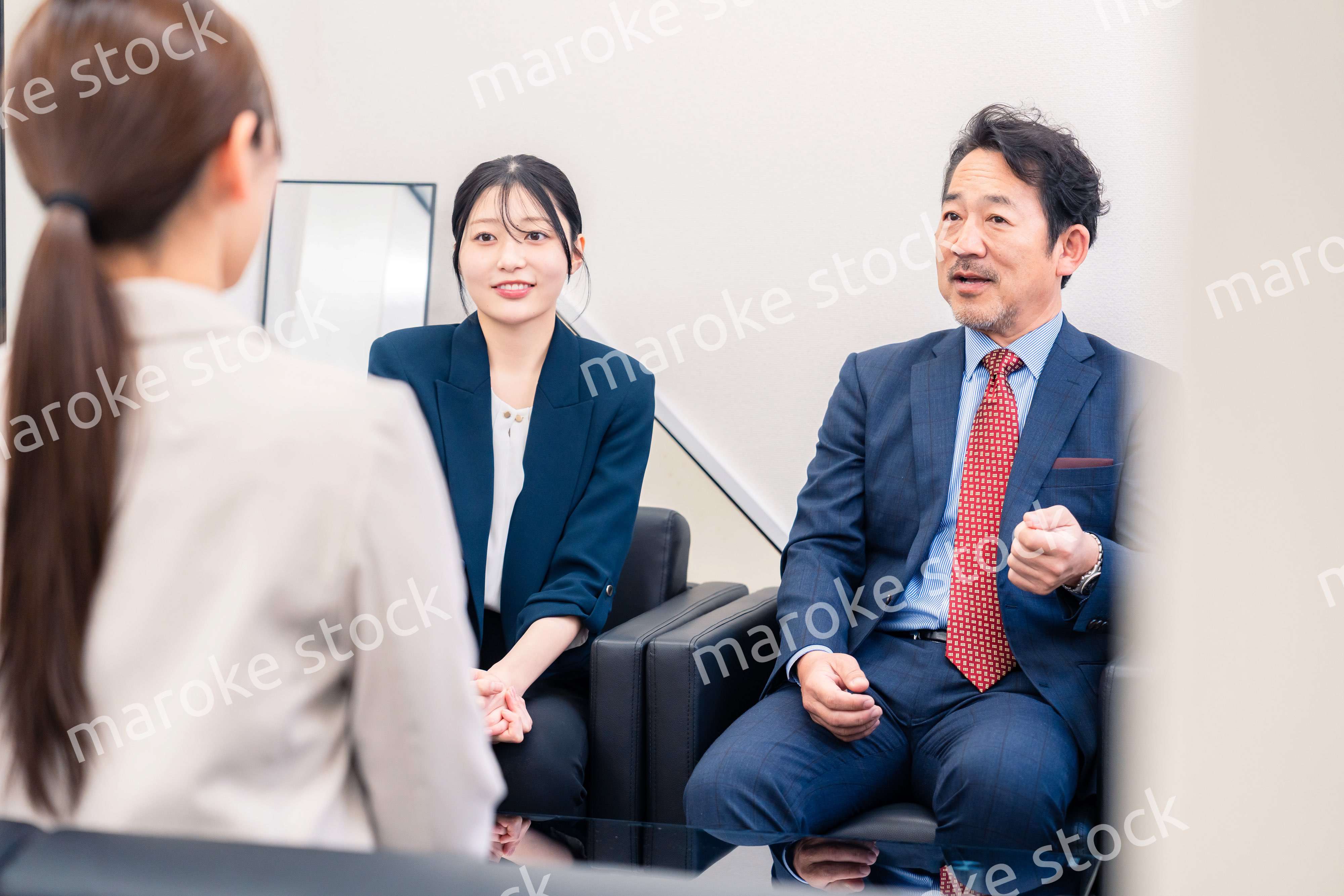 オフィスで楽しく会話をする中年男性とビジネスウーマン