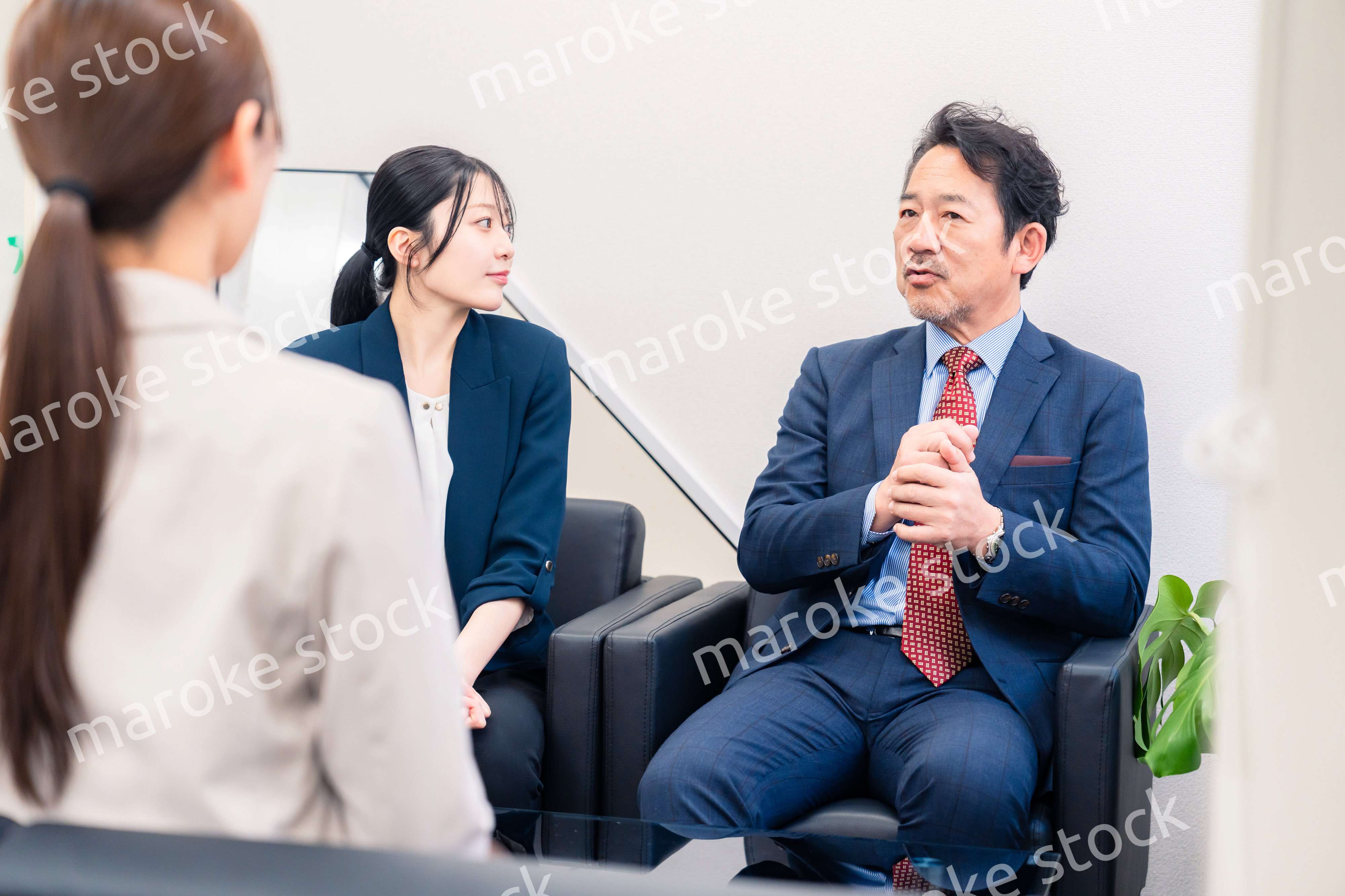 オフィスで楽しく会話をする中年男性とビジネスウーマン