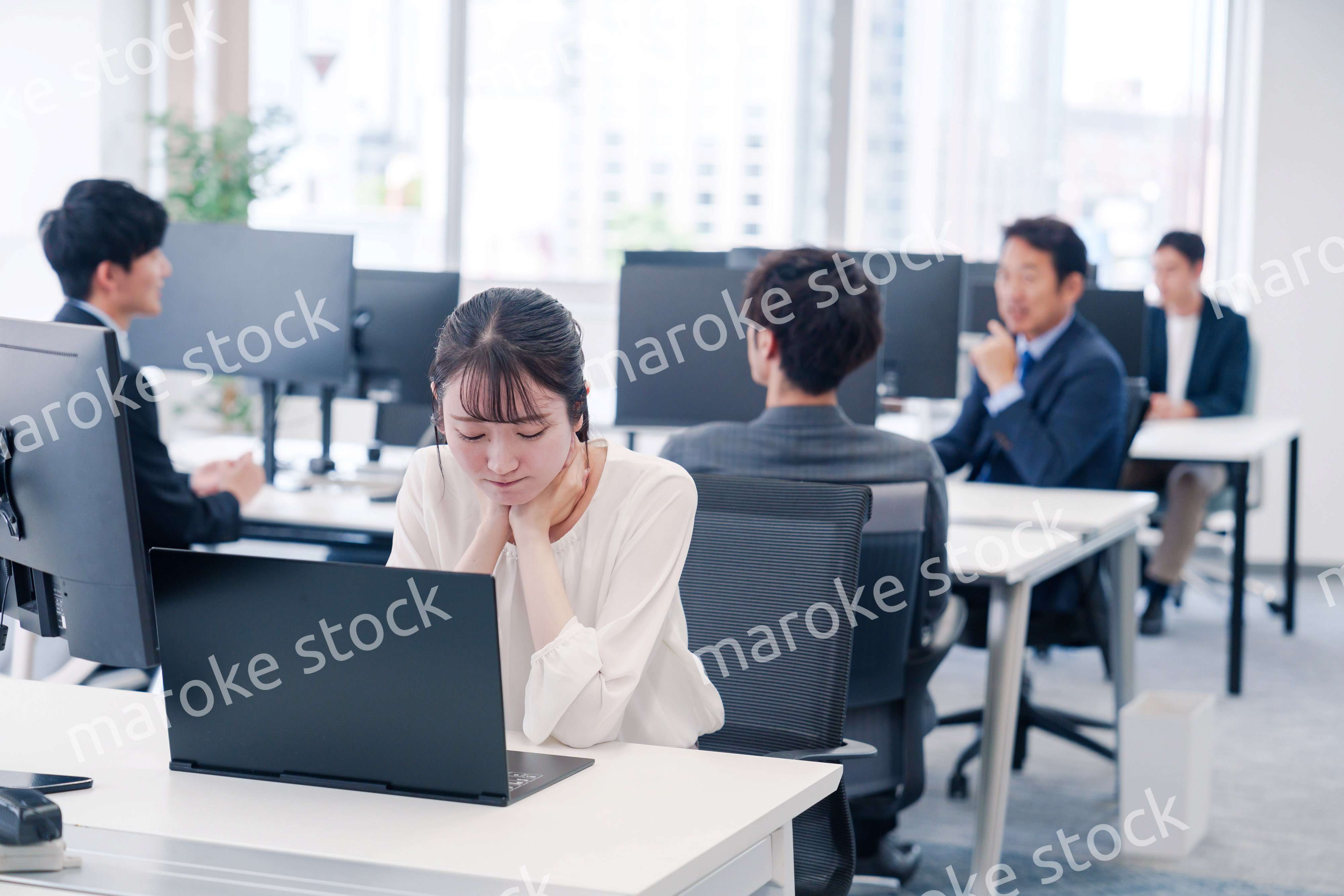 長時間のデスクワークで疲れたビジネスウーマン