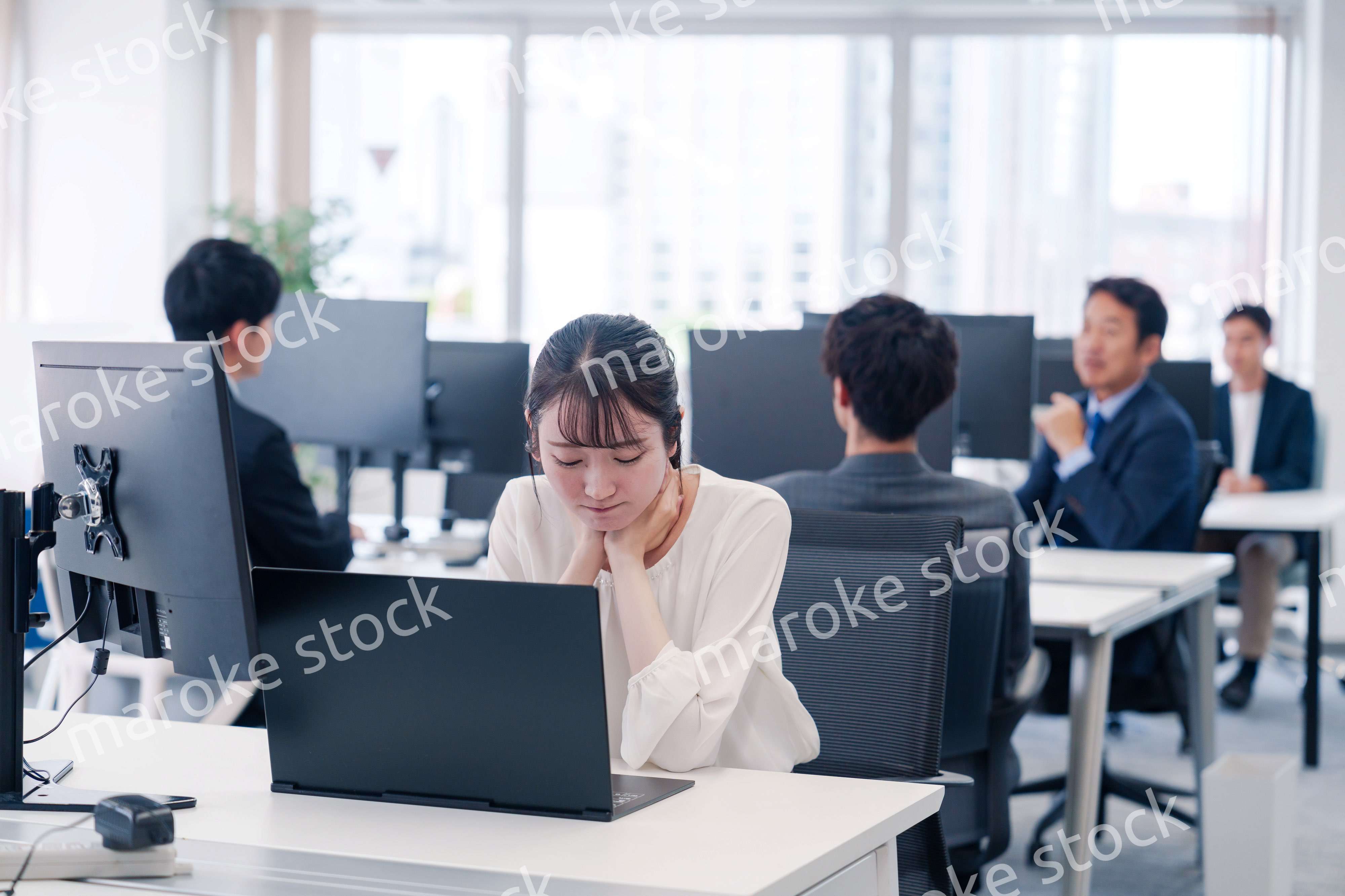 長時間のデスクワークで疲れたビジネスウーマン