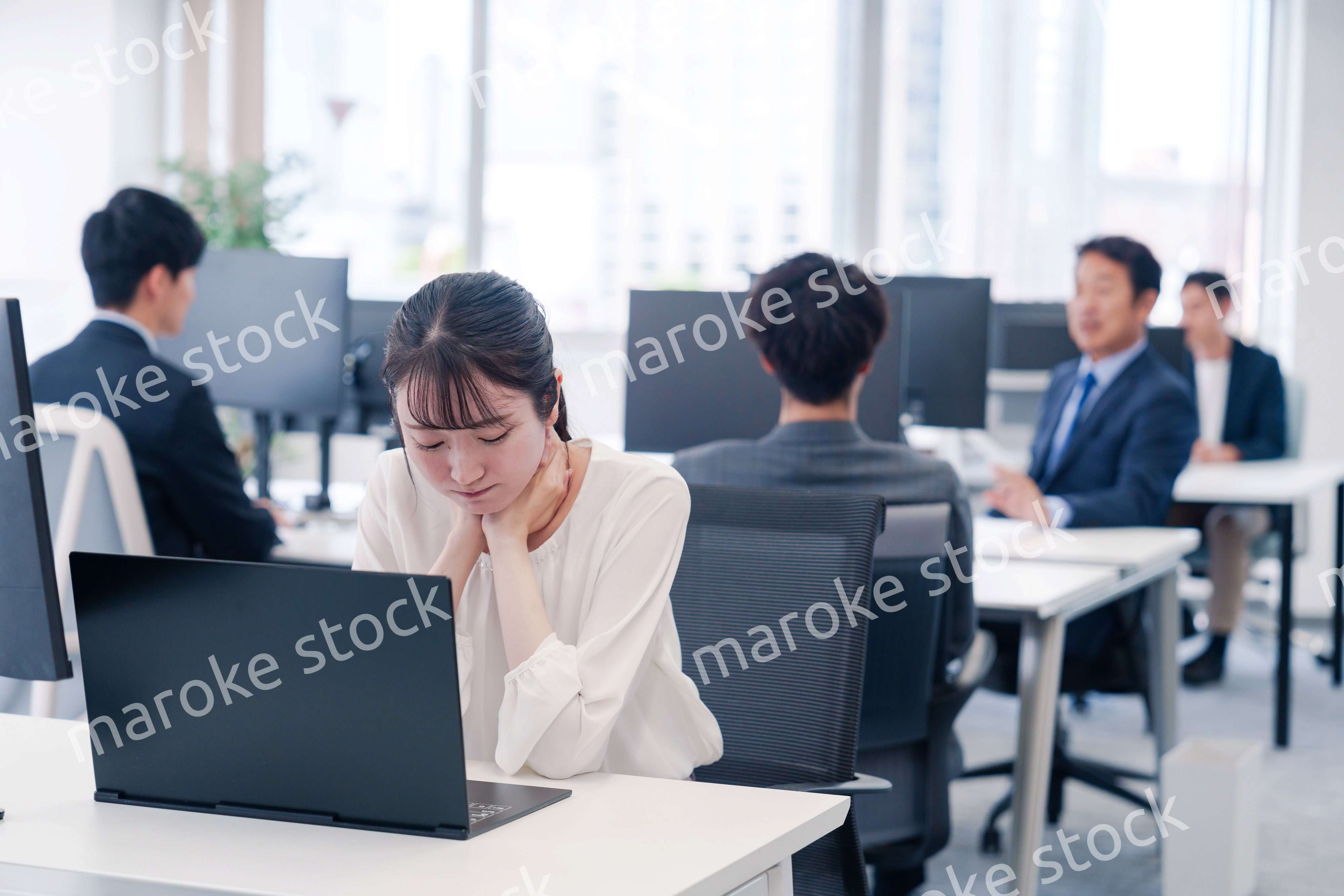 長時間のデスクワークで疲れたビジネスウーマン