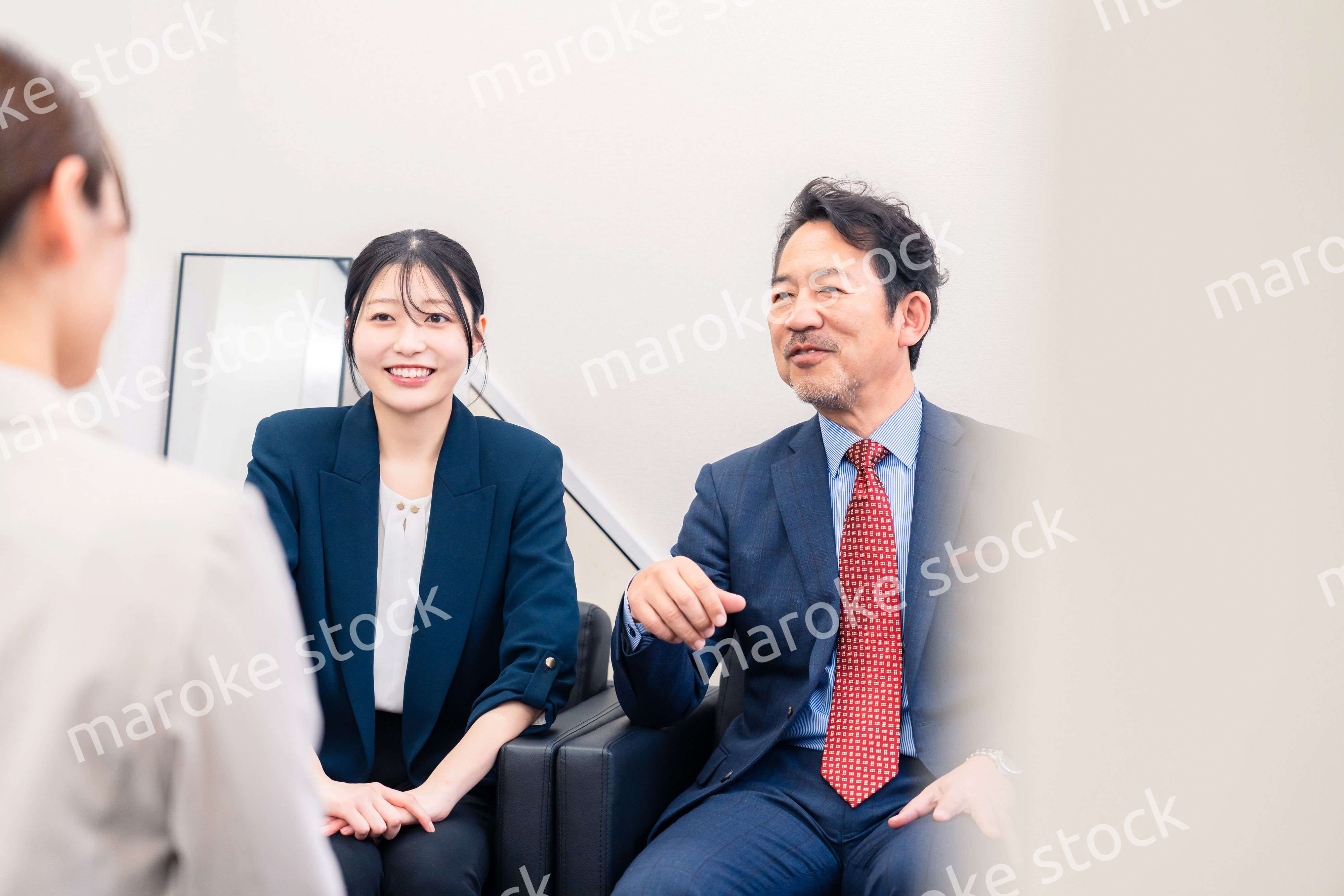 オフィスで楽しく会話をする中年男性とビジネスウーマン