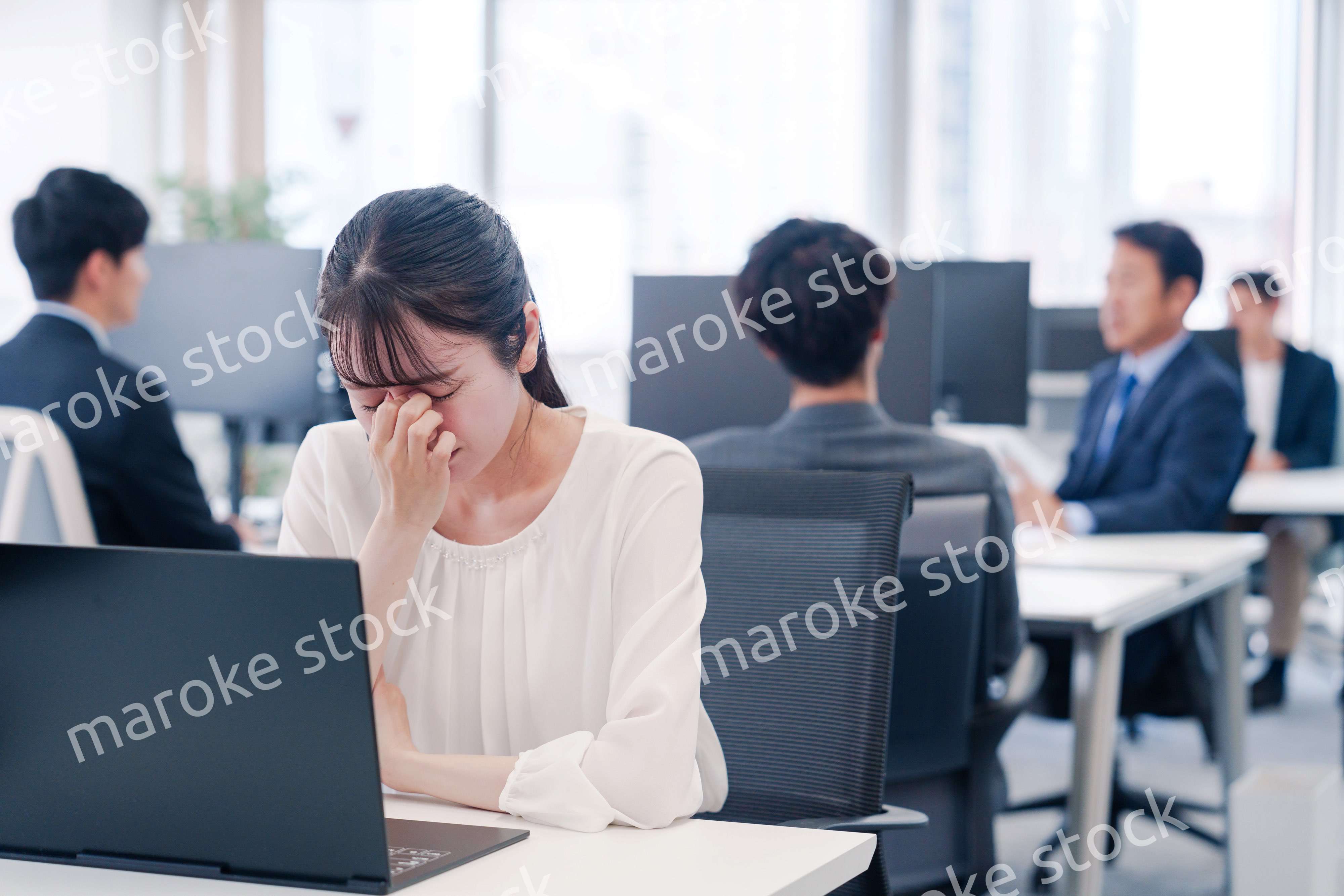 長時間のデスクワークで疲れたビジネスウーマン