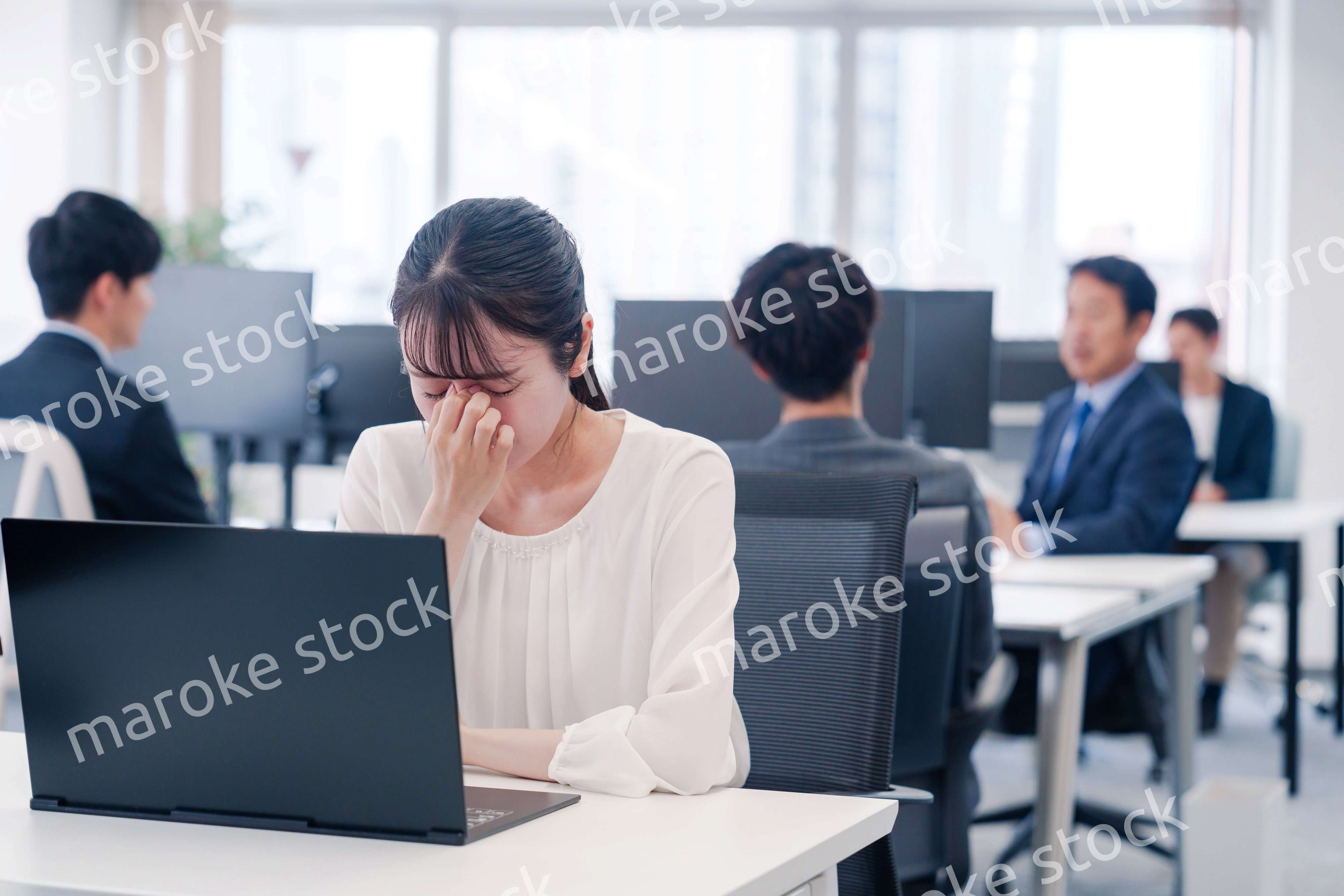 長時間のデスクワークで疲れたビジネスウーマン