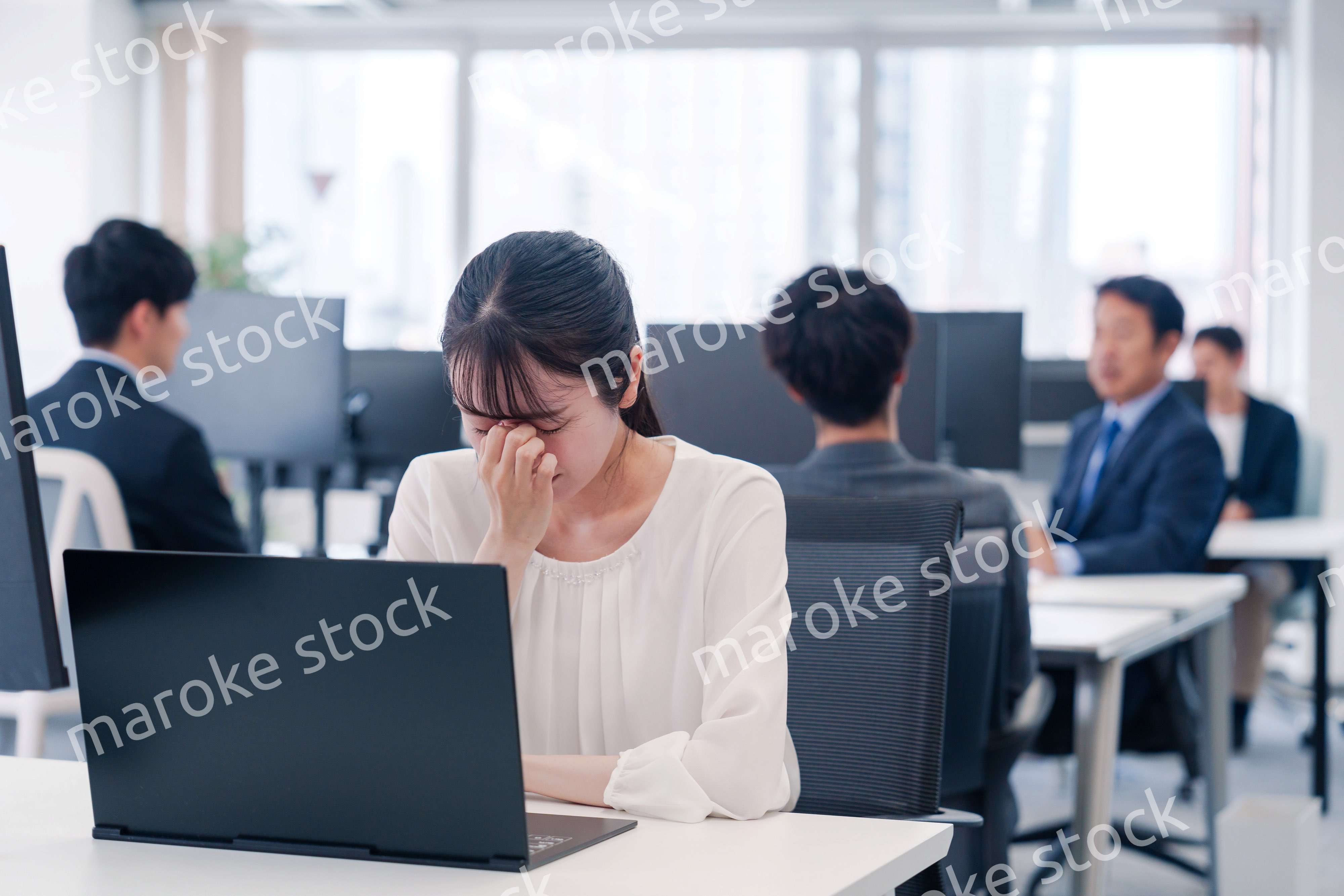 長時間のデスクワークで疲れたビジネスウーマン