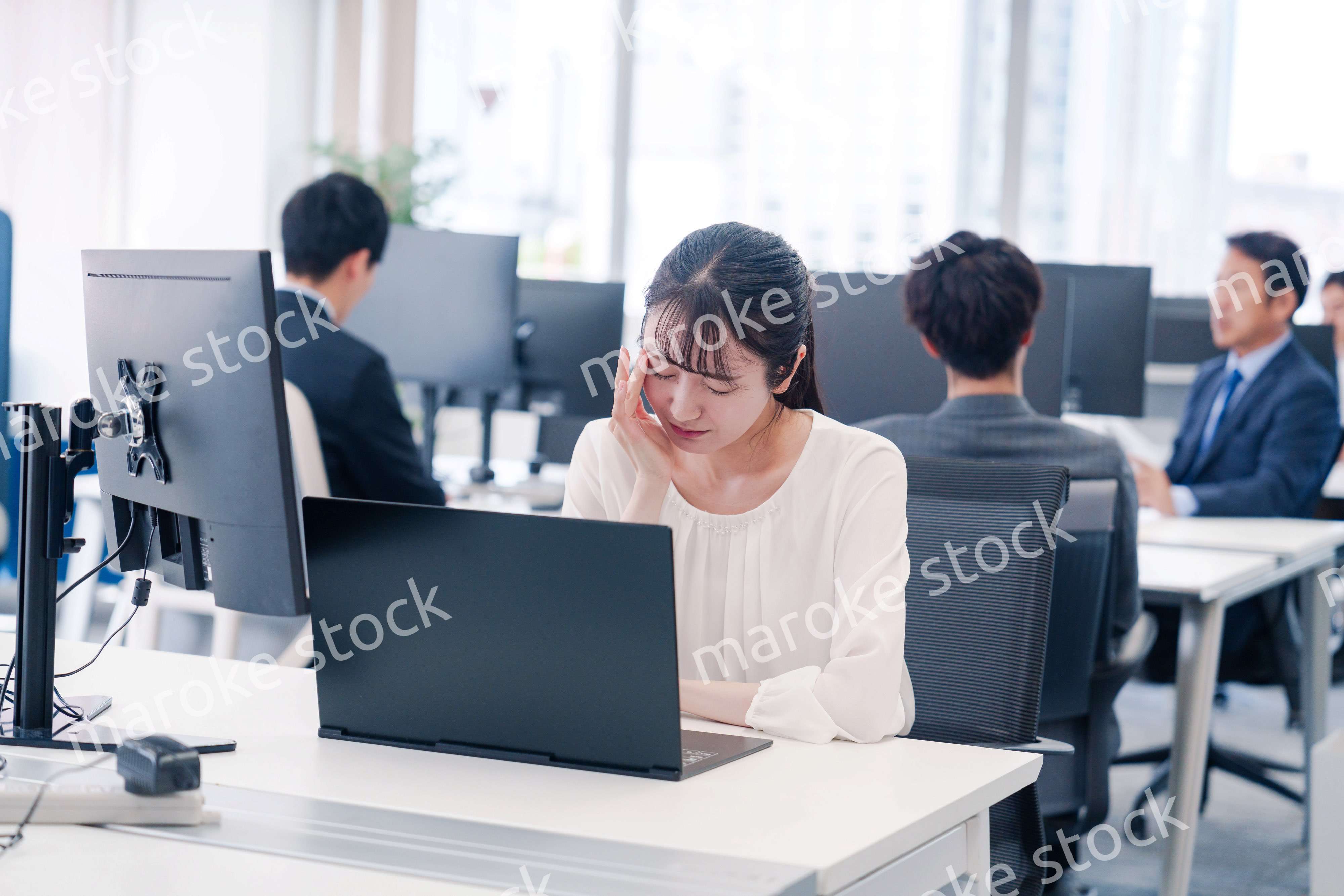 長時間のデスクワークで疲れたビジネスウーマン