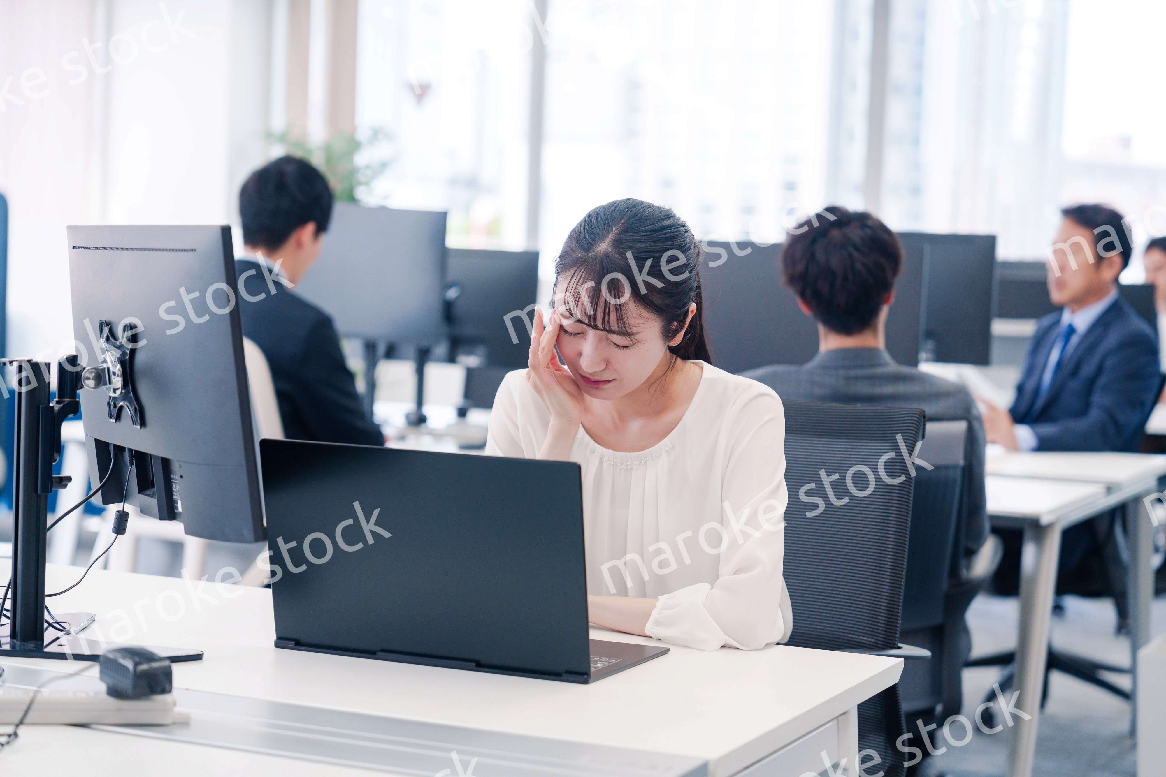 長時間のデスクワークで疲れたビジネスウーマン