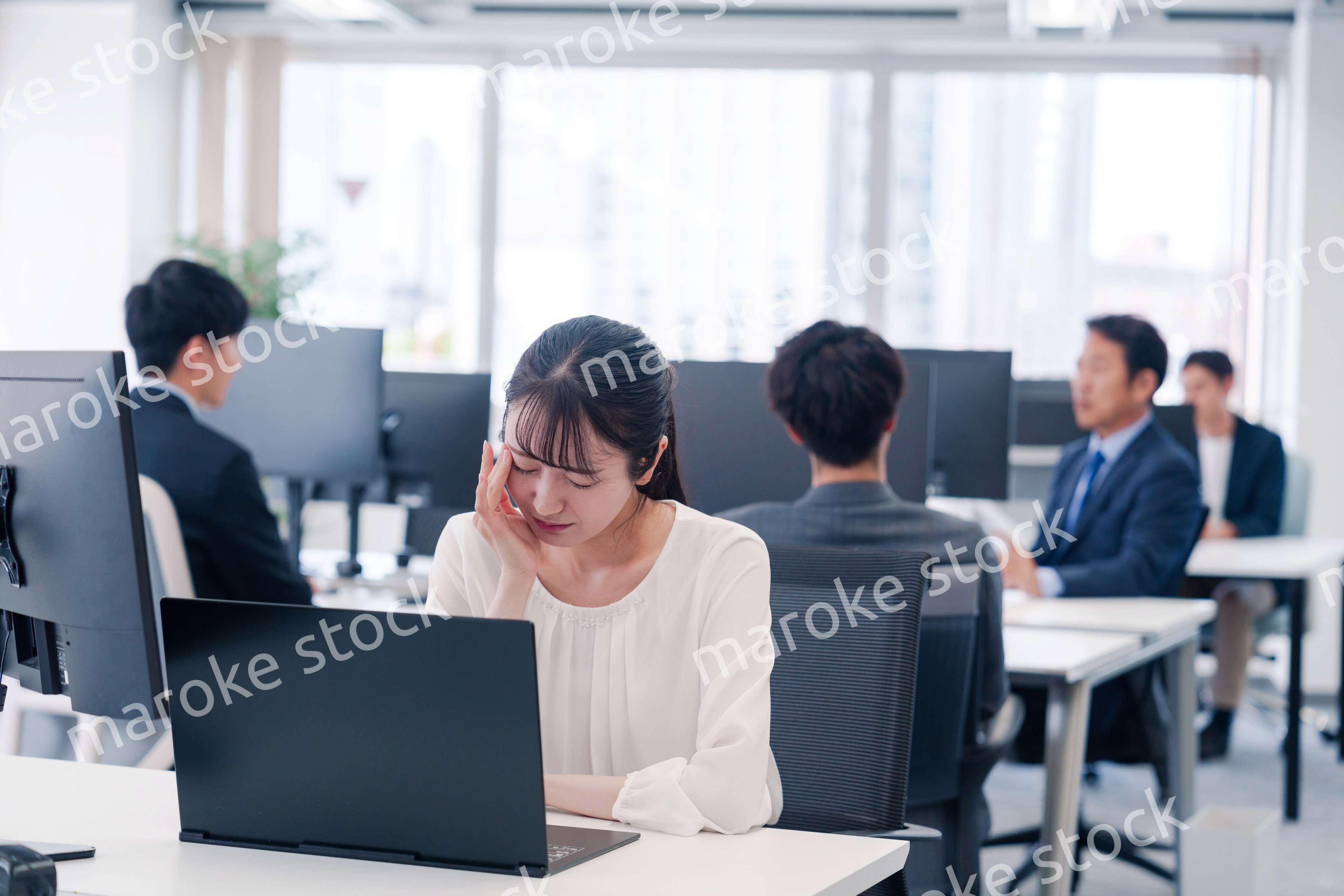 長時間のデスクワークで疲れたビジネスウーマン