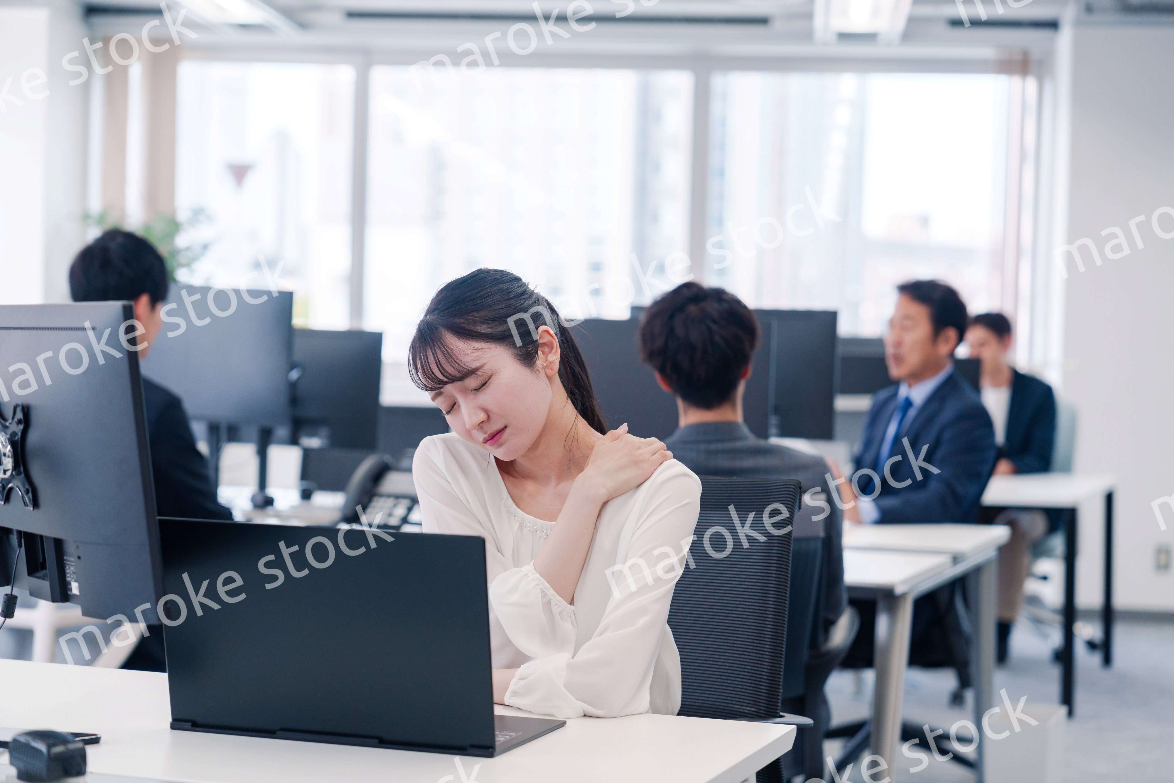 長時間のデスクワークで疲れたビジネスウーマン