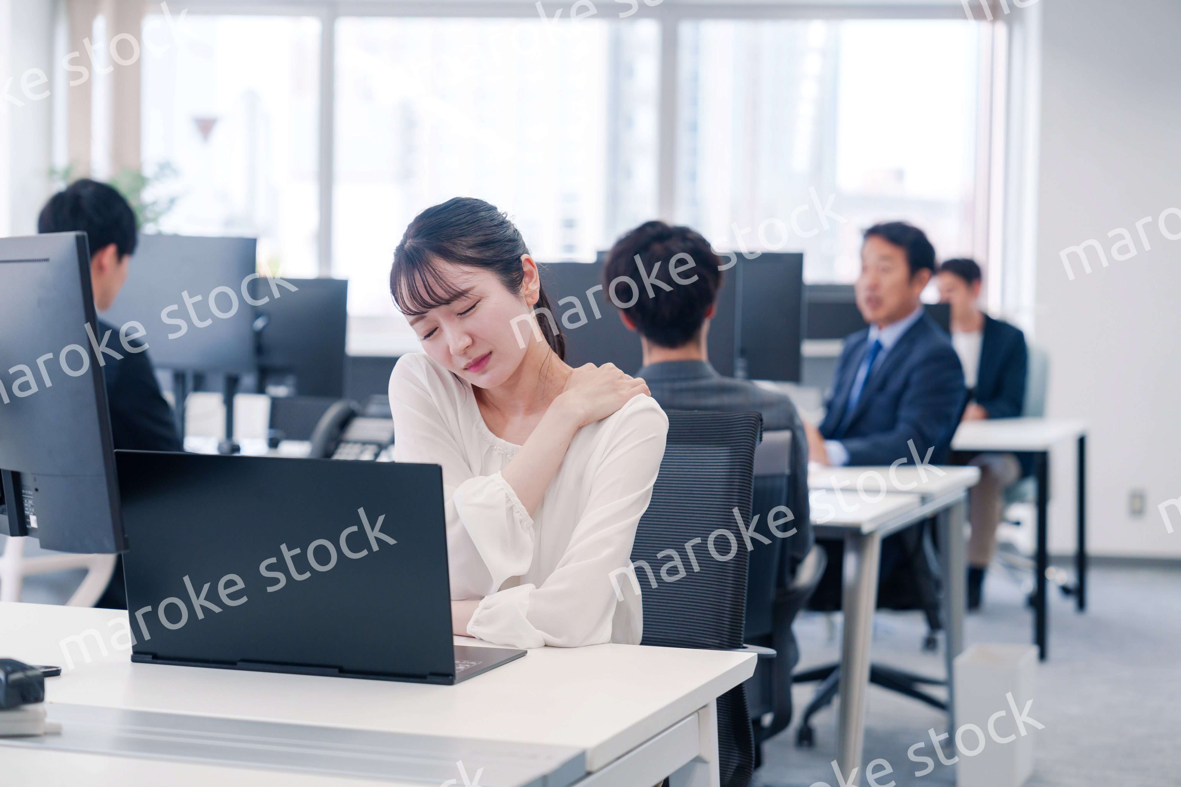 長時間のデスクワークで疲れたビジネスウーマン